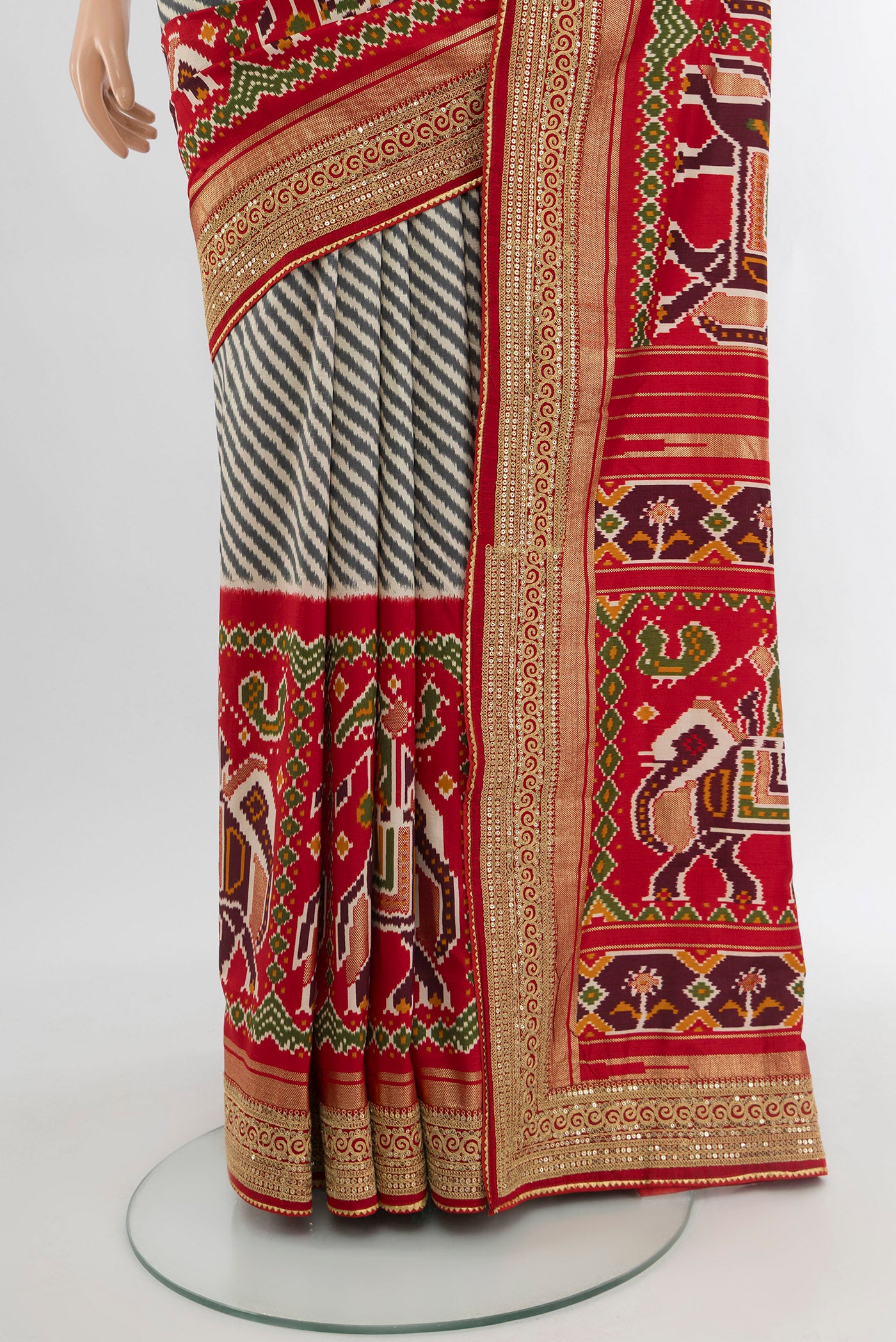 Pleats and pallu of Off White Art Silk Saree with Embroidery on the body and Zari Border. 
