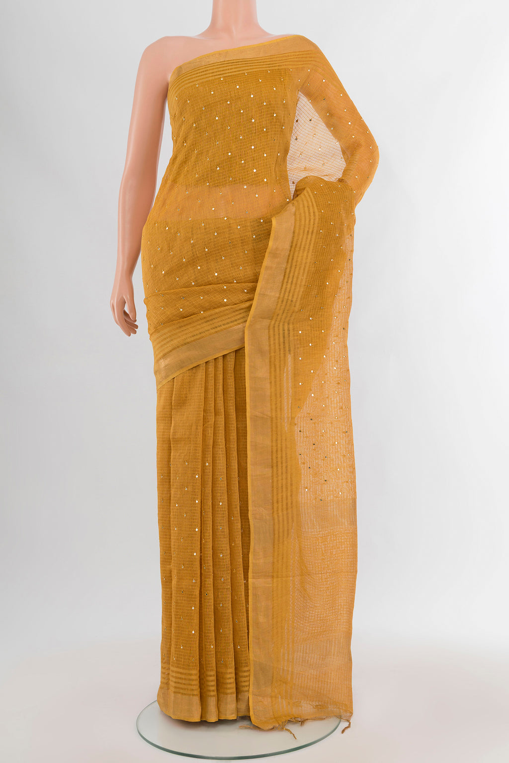 Mustard Tussar Silk Saree with Embroidery on the body and Zari Border.  displayed on a mannequin
