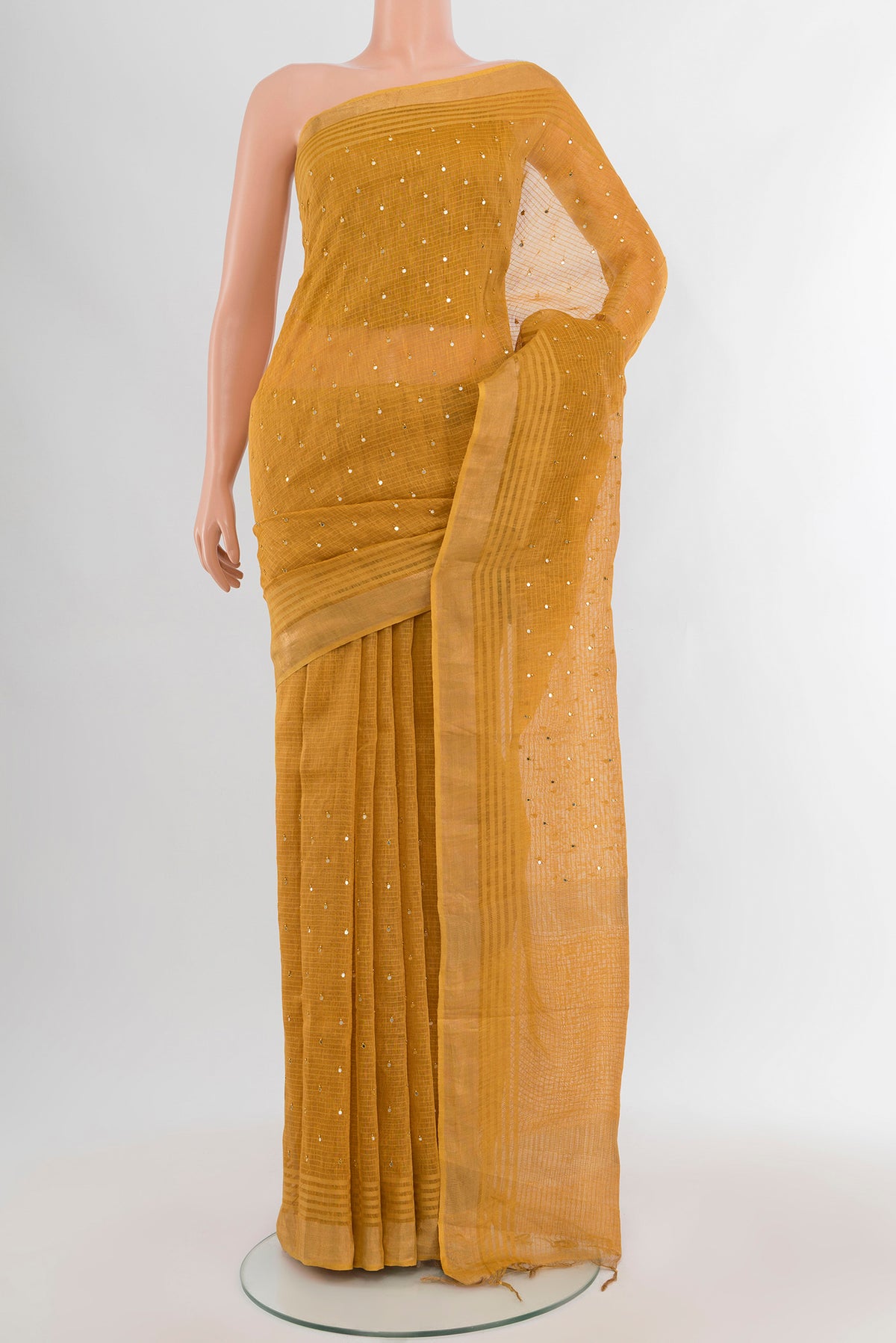 Mustard Tussar Silk Saree with Embroidery on the body and Zari Border.  displayed on a mannequin