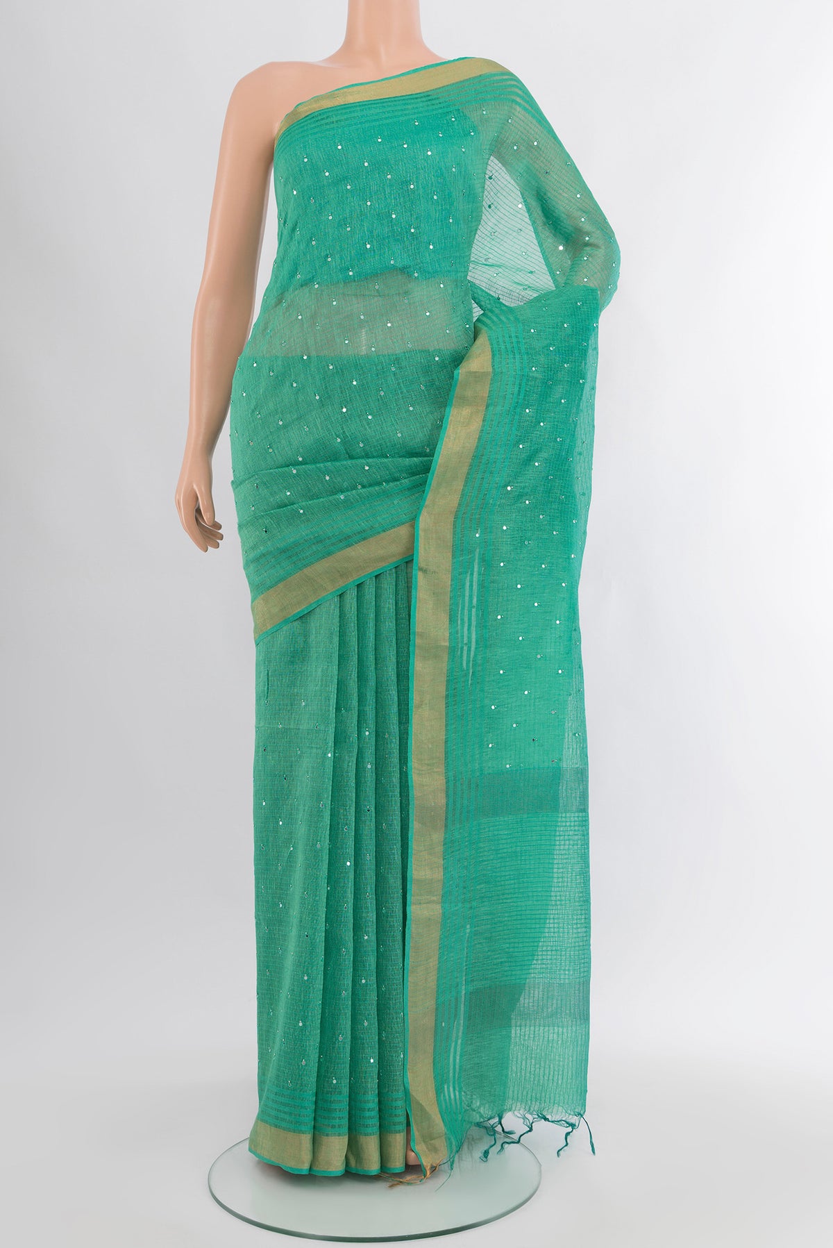 Sea Green Tussar Silk Saree with Embroidery on the body and Zari Border.  displayed on a mannequin