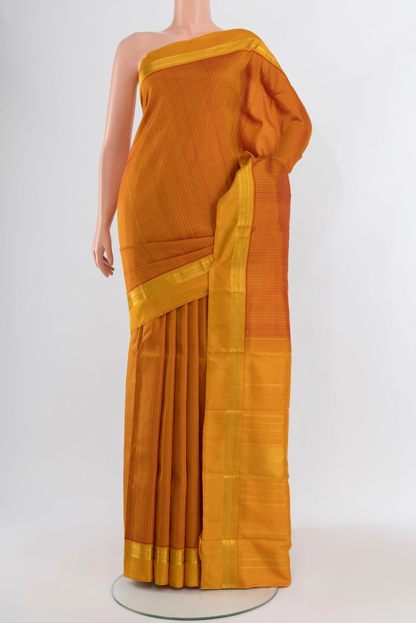 Mustard Kanchipuram Silk Saree with Stripes on the body and Zari Border.  displayed on a mannequin