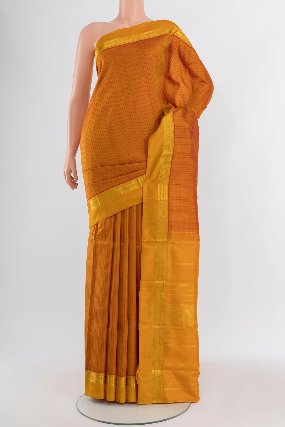 Mustard Kanchipuram Silk Saree with Stripes on the body and Zari Border.  displayed on a mannequin