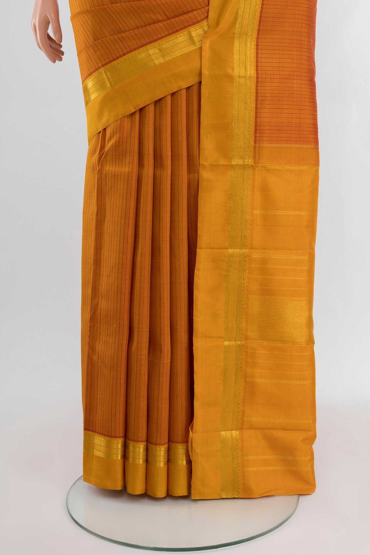 Pleats and pallu of Mustard Kanchipuram Silk Saree with Stripes on the body and Zari Border. 