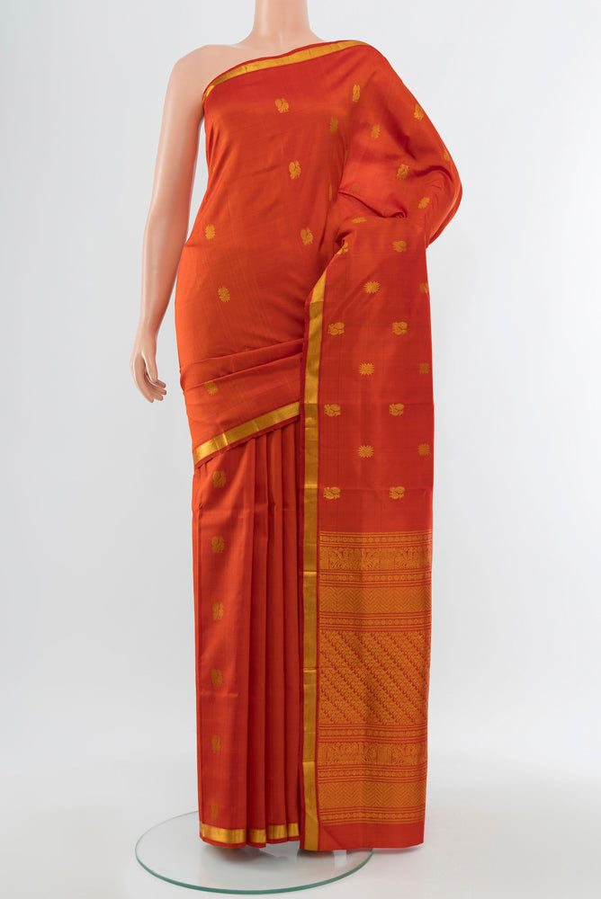 Brick Orange Kanjivaram Silk Saree with Zari Butta on the body and Silk Border.  displayed on a mannequin