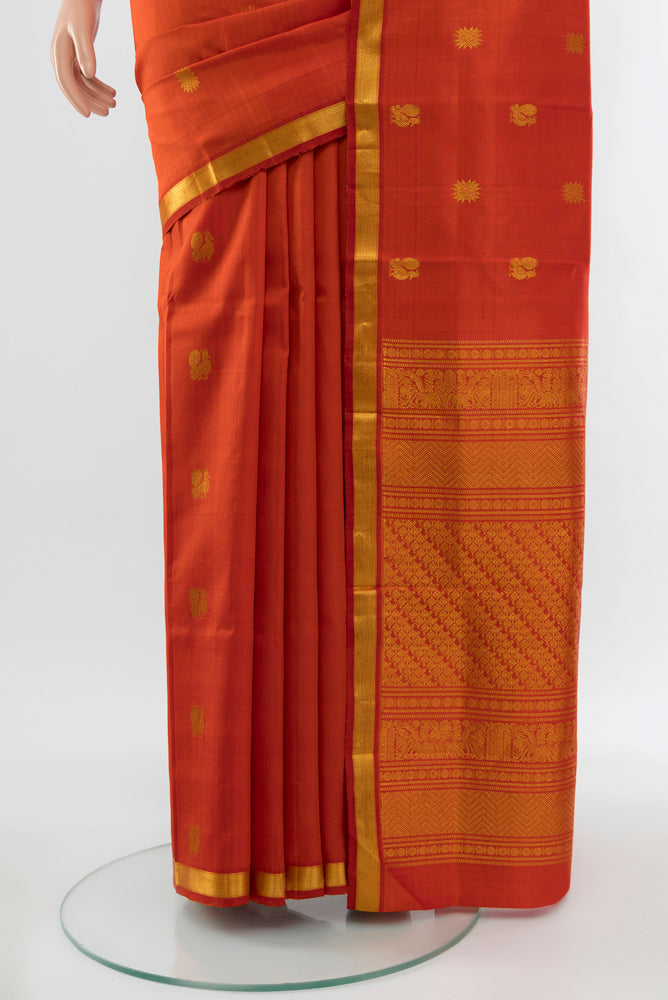 Pleats and pallu of Brick Orange Kanjivaram Silk Saree with Zari Butta on the body and Silk Border. 