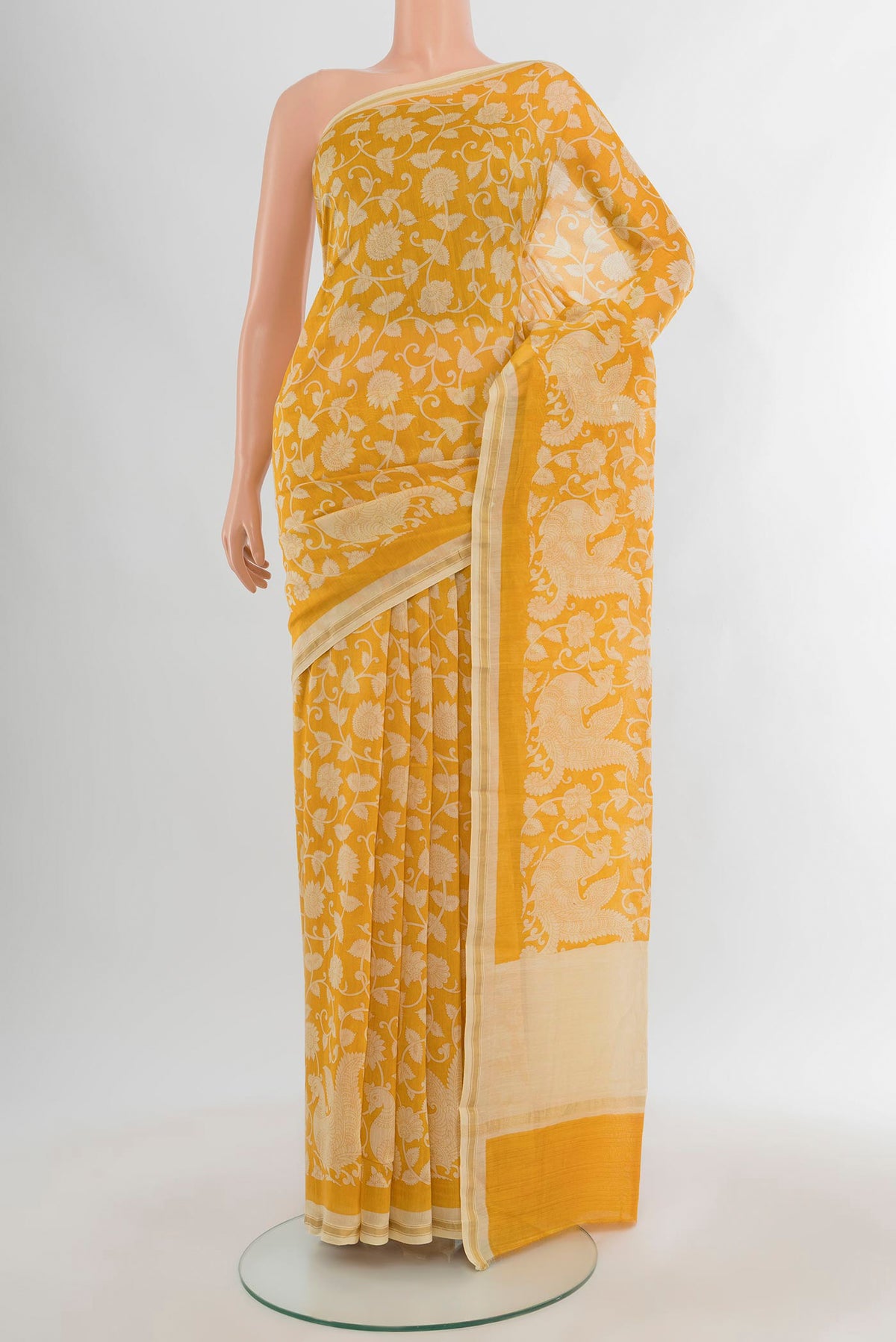 Yellow Maheshwari Silk Cotton Saree with Floral Print on the body and Zari Border.  displayed on a mannequin