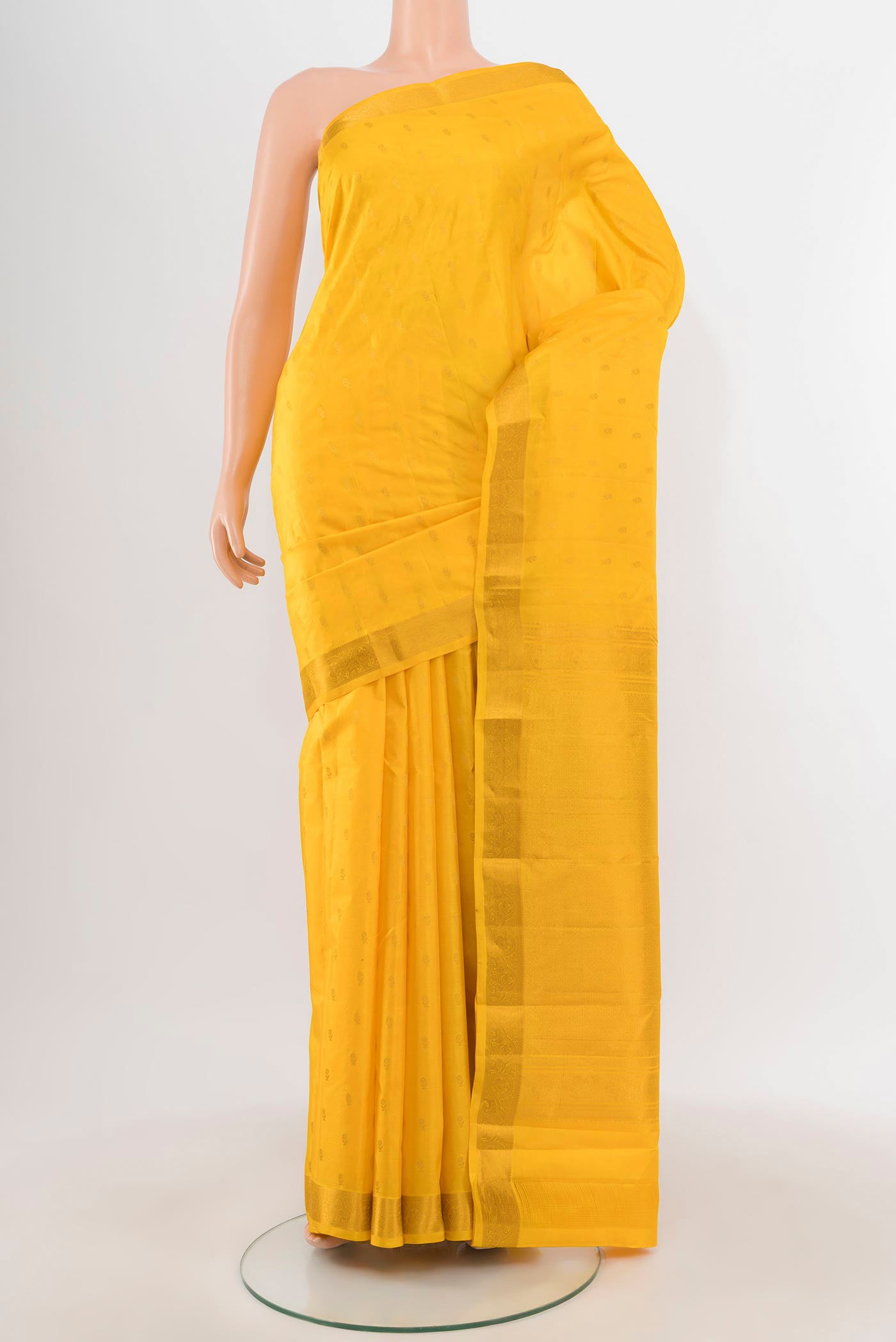 Yellow Kanchipuram Silk Saree with Zari Butta on the body and Zari Border.  displayed on a mannequin