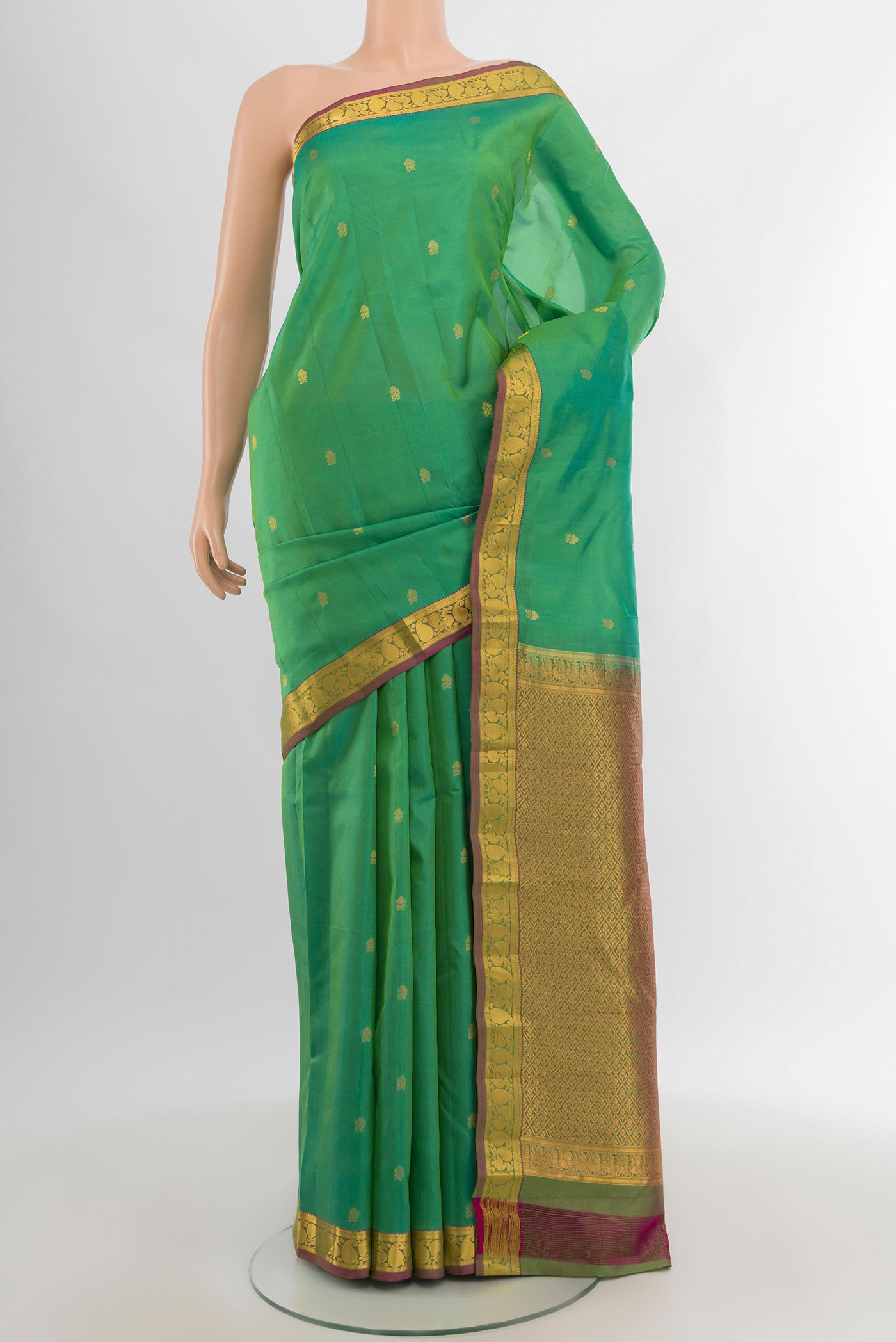 Light Green Kanjivaram Silk Saree with Zari Butta on the body and Zari Border.  displayed on a mannequin