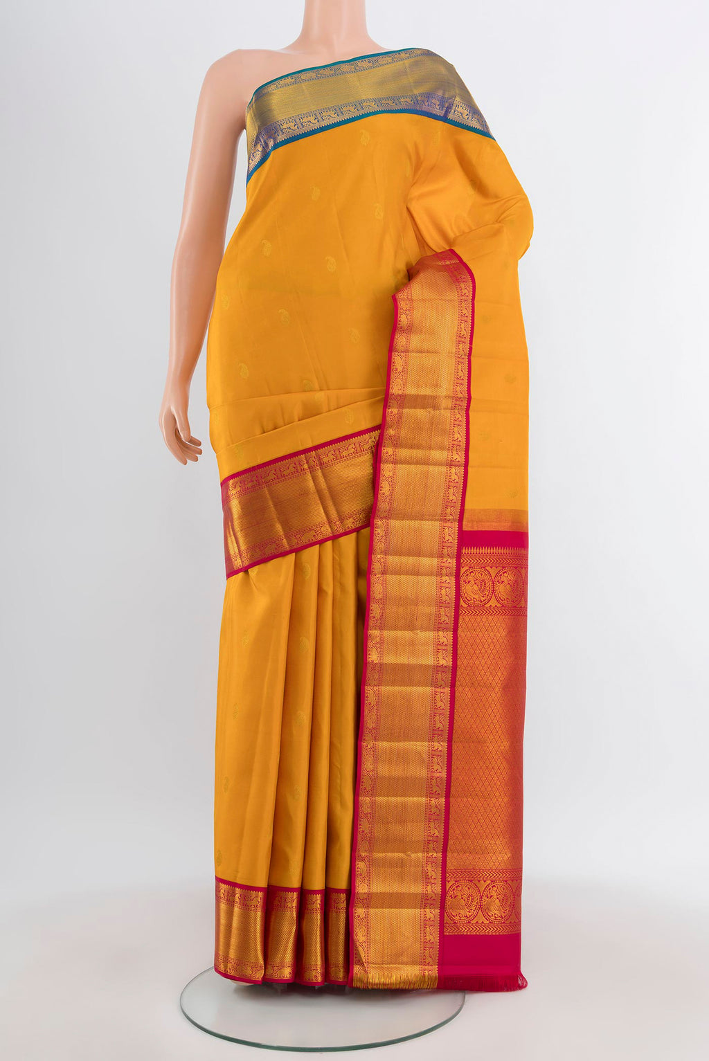 Mustard Kanjivaram Silk Saree with Zari Butta on the body and Ganga Jamuna Border.  displayed on a mannequin