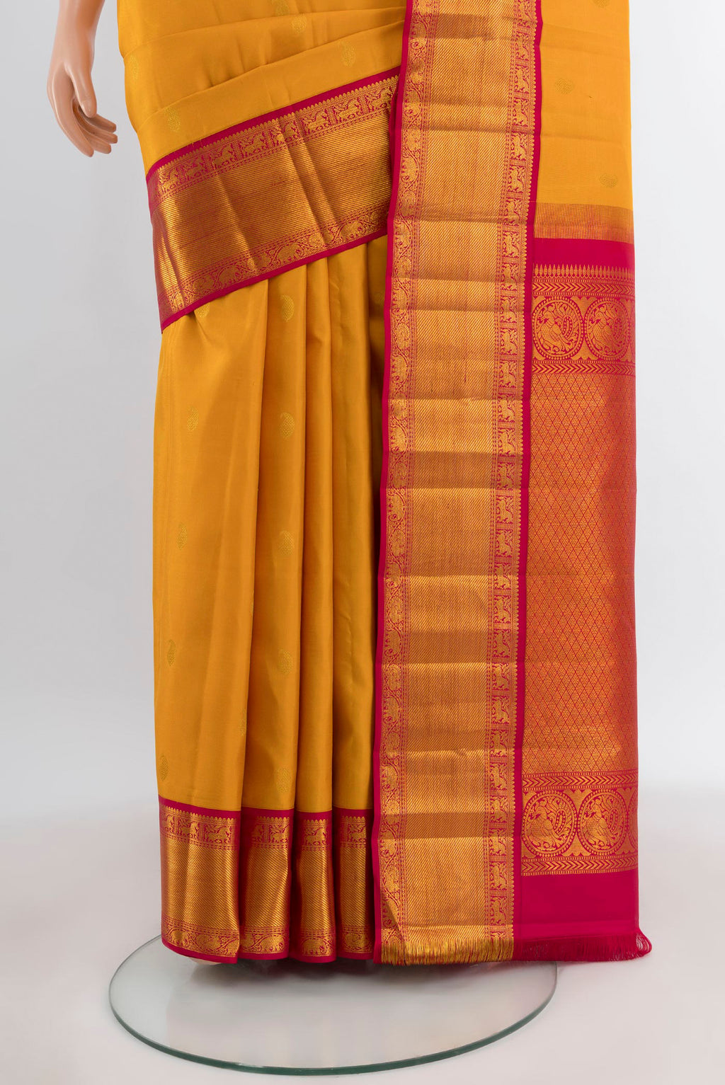 Pleats and pallu of Mustard Kanjivaram Silk Saree with Zari Butta on the body and Ganga Jamuna Border. 
