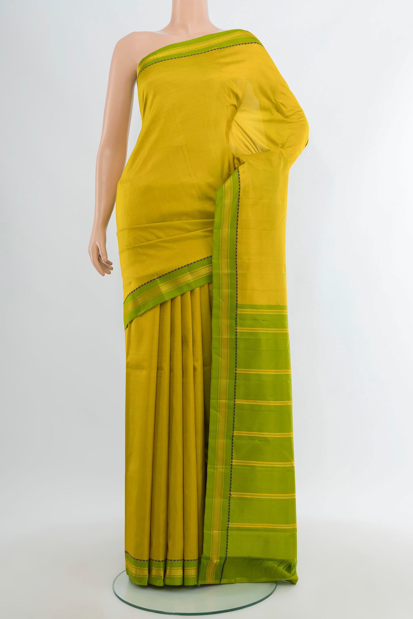 Light Green Kanjivaram Silk Saree with Plain Body and Zari Border.  displayed on a mannequin