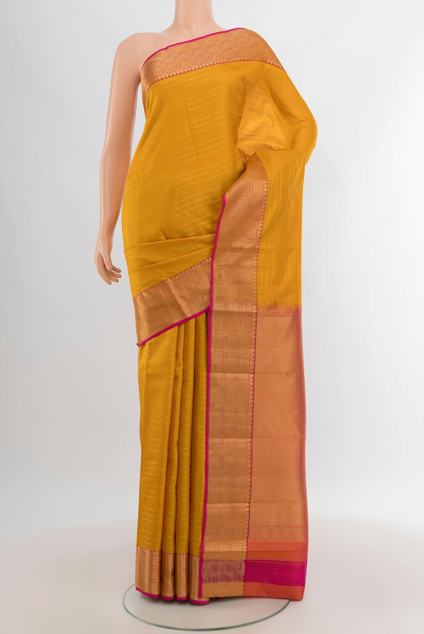 Mustard Kanchipuram Silk Saree with Stripes on the body and Zari Border.  displayed on a mannequin