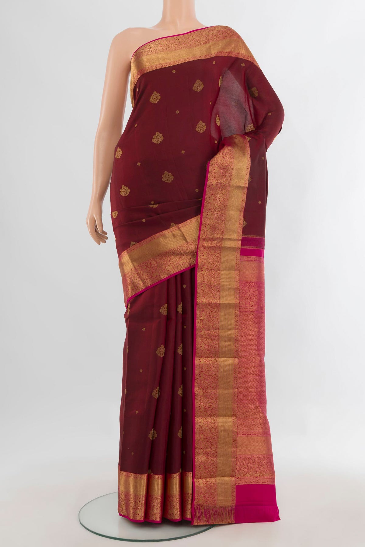 Pure Silk Maroon Kanjivaram Saree with Zari Butta on the body and Zari Border.  displayed on a mannequin