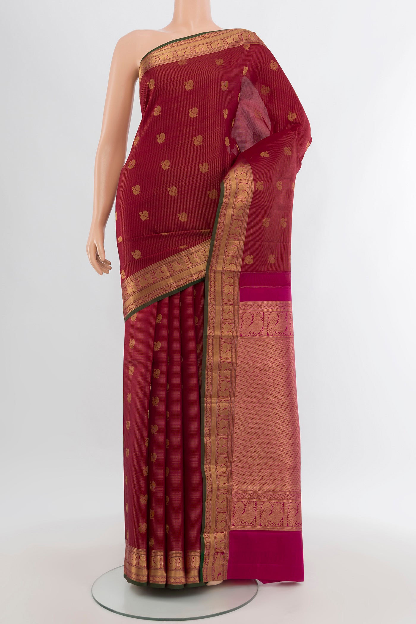 Maroon Kanchipuram Silk Saree with Zari Butta on the body and Zari Border.  displayed on a mannequin
