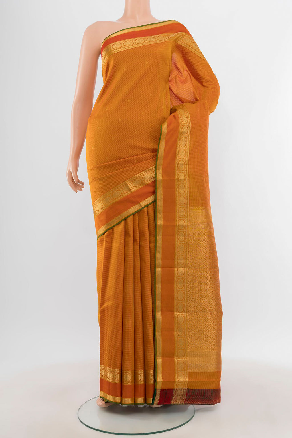 Mustard Kanjivaram Silk Saree with Zari Butta on the body and Zari Border.  displayed on a mannequin