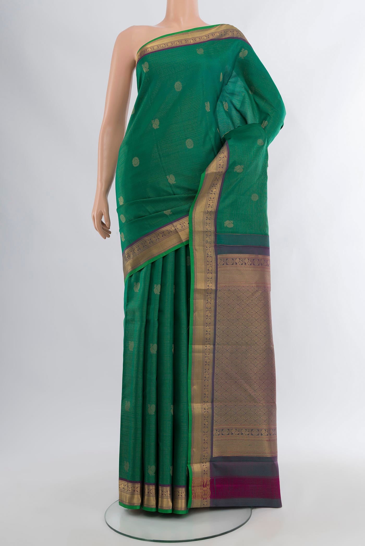Green Kanchipuram Silk Saree with Zari Butta on the body and Zari Border.  displayed on a mannequin