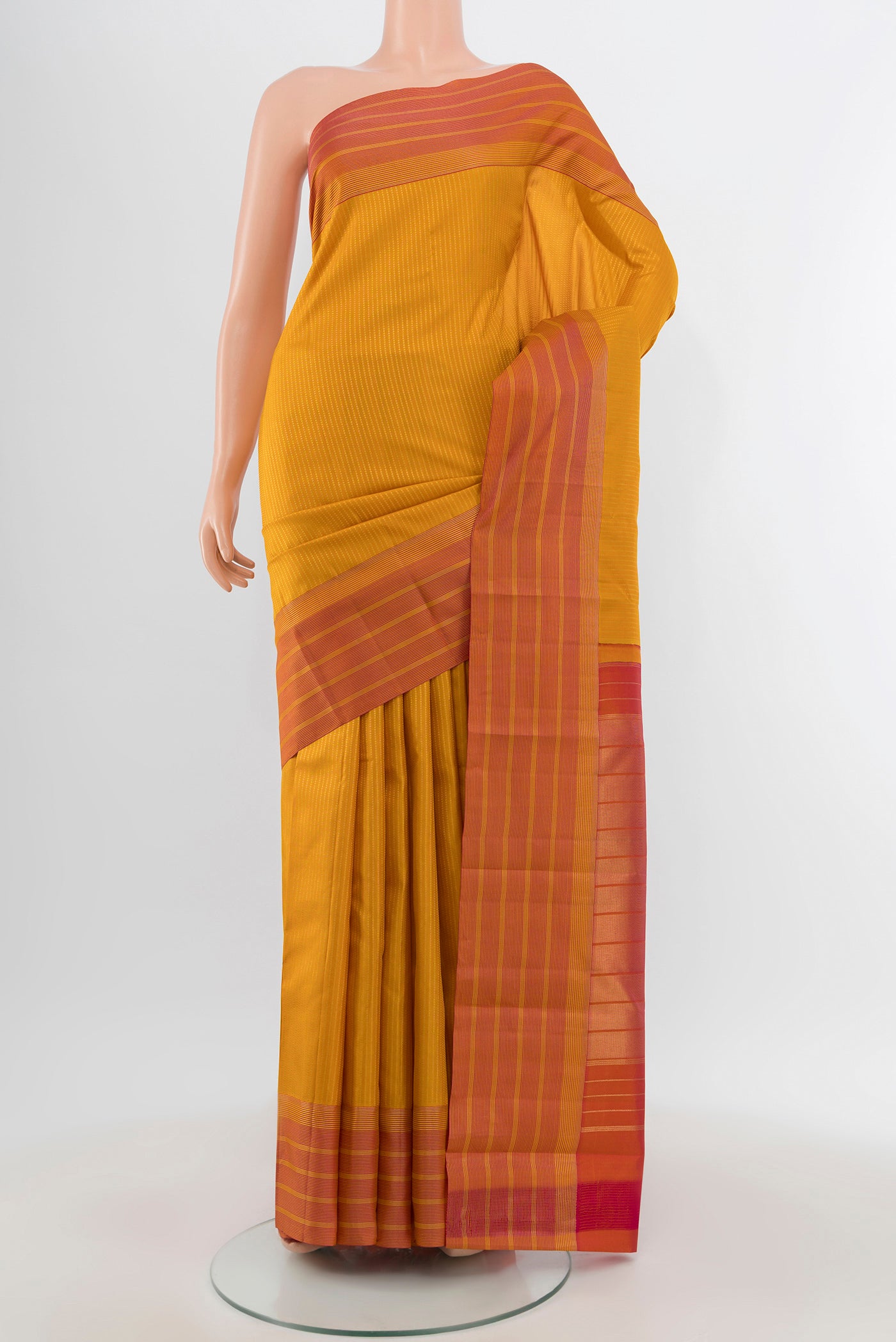 Mustard Kanchipuram Silk Saree with Stripes on the body and Zari Border.  displayed on a mannequin