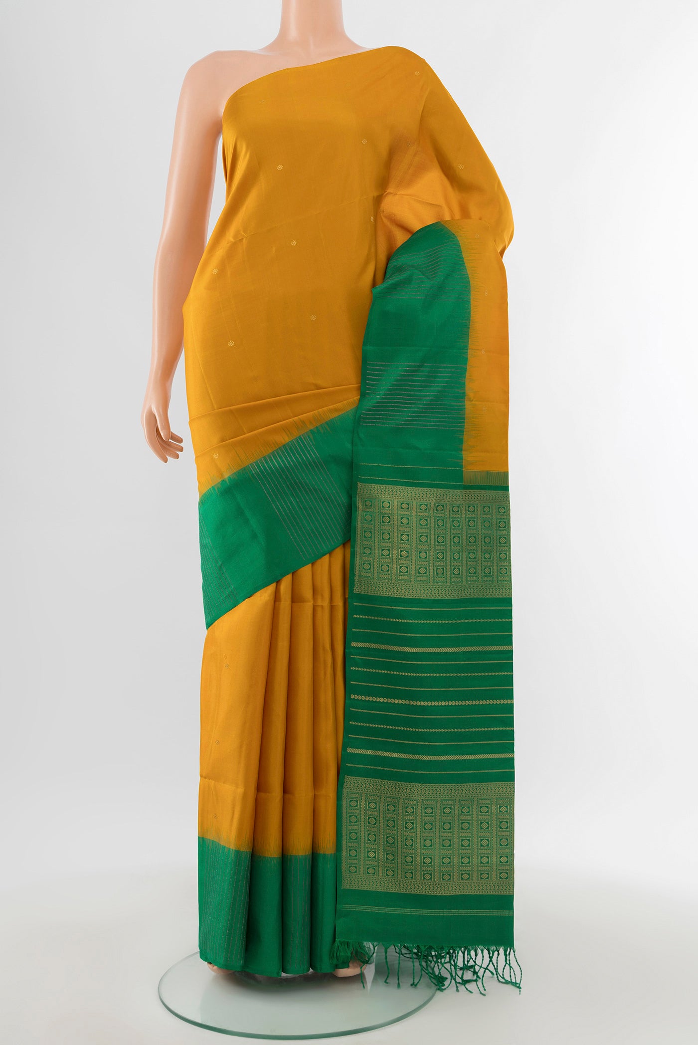 Mustard Soft Silk Saree with Zari Butta on the body and Fancy Border.  displayed on a mannequin
