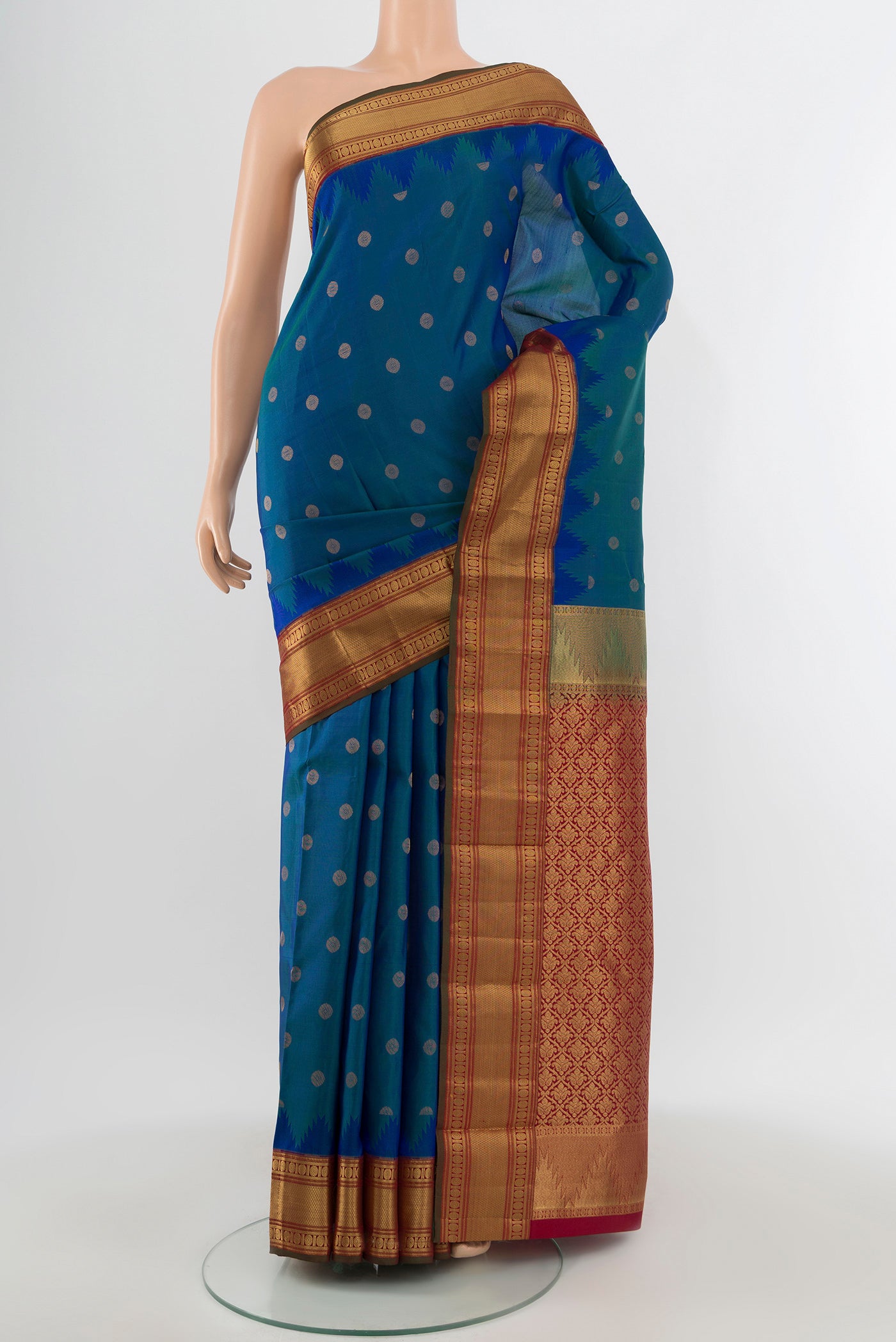 Peacock Blue Kanchipuram Silk Saree with Zari Butta on the body and Zari Border.  displayed on a mannequin