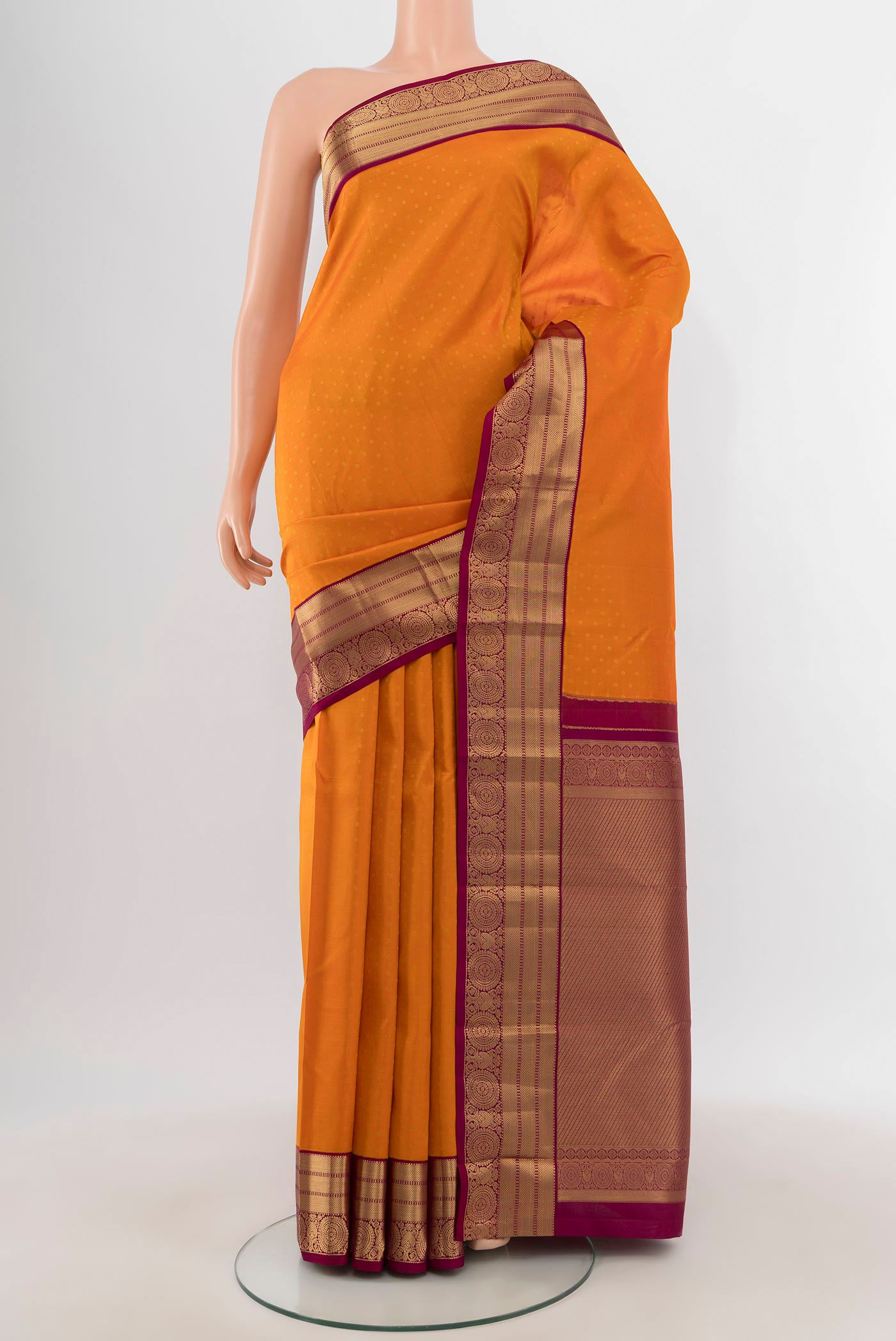 Orange Kanchipuram Silk Saree with Zari Butta on the body and Zari Border.  displayed on a mannequin