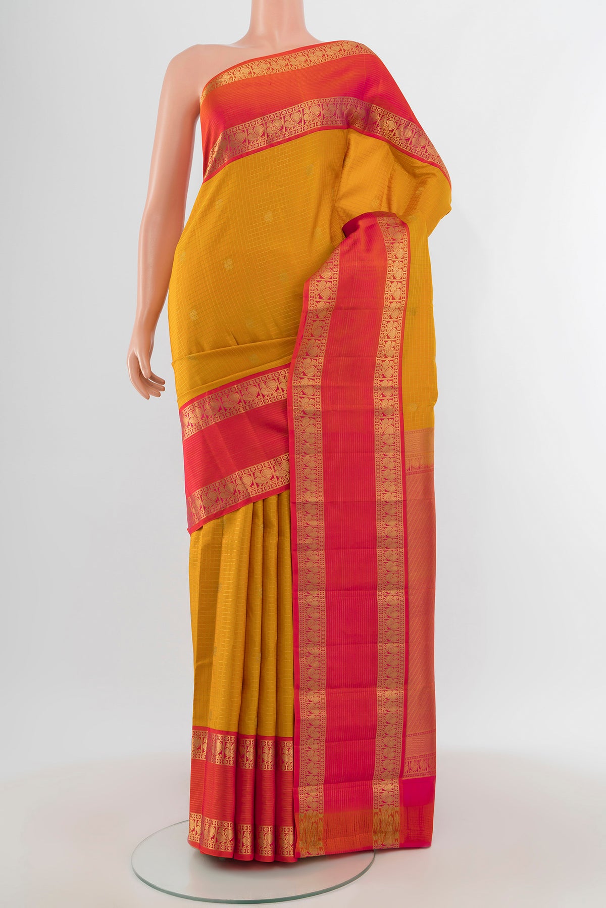 Mustard Kanchipuram Silk Saree with Checked design on the body and Zari Border.  displayed on a mannequin