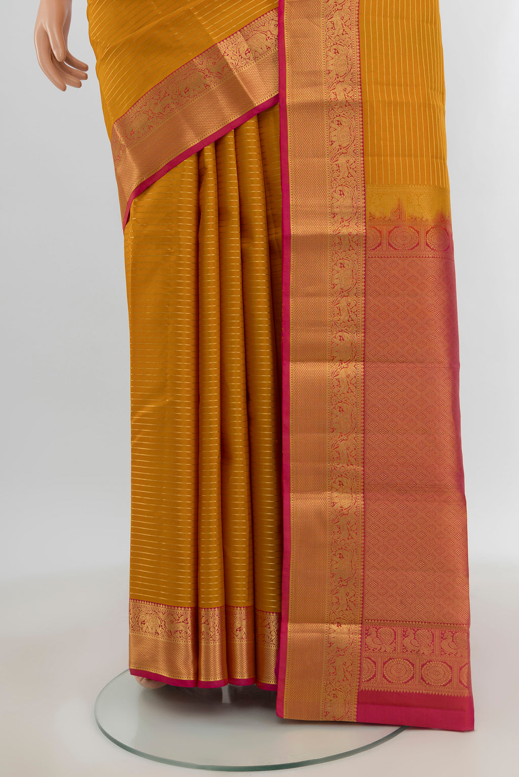 Pleats and pallu of Mustard Kanjivaram Silk Saree with Stripes on the body and Zari Border. 