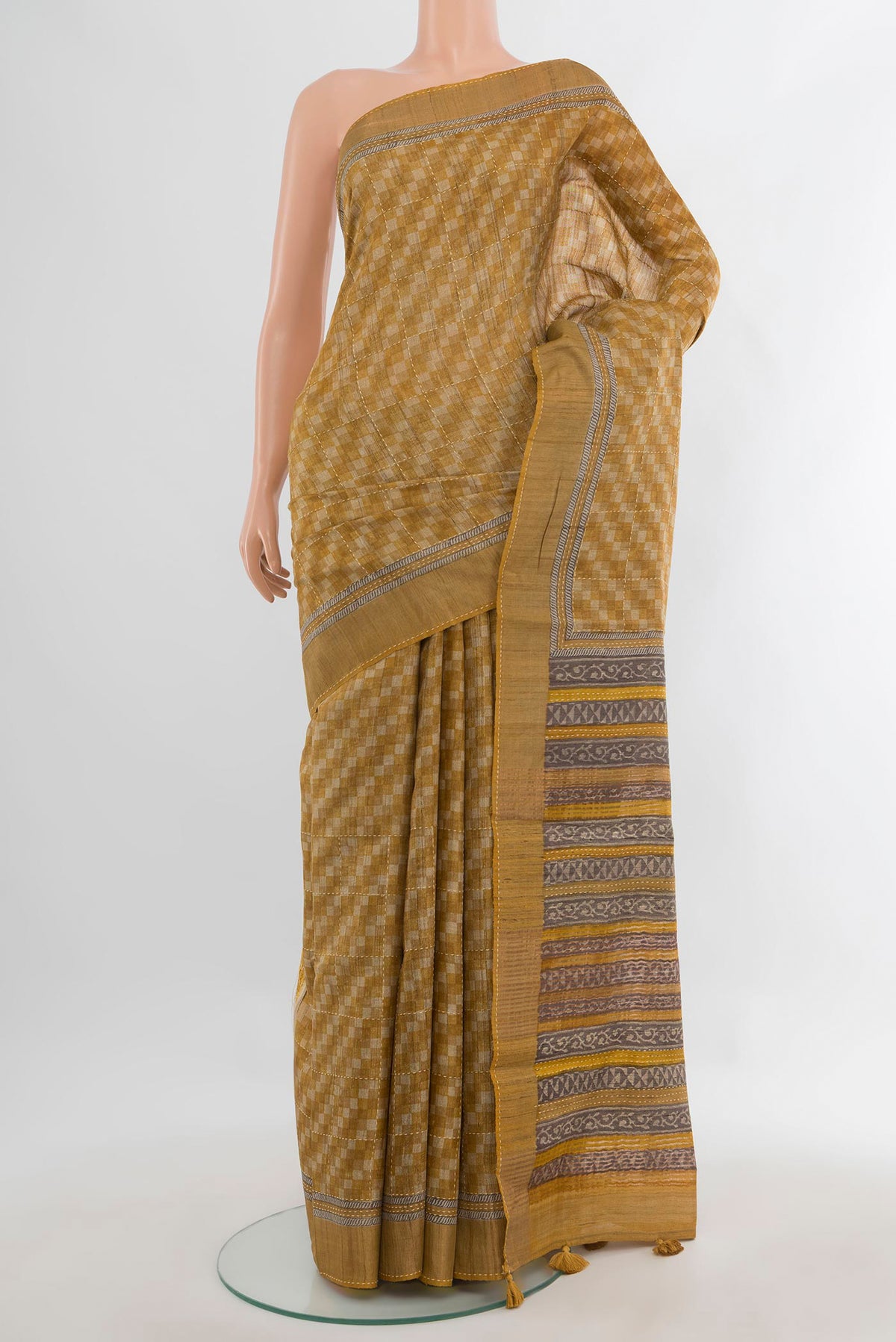Mustard Tussar Saree with Embroidery on the body and Zari Border.  displayed on a mannequin