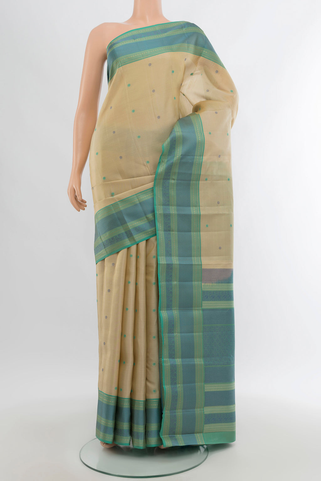 Beige Kanchipuram Silk Saree with Thread Butta on the body and Thread Border.  displayed on a mannequin