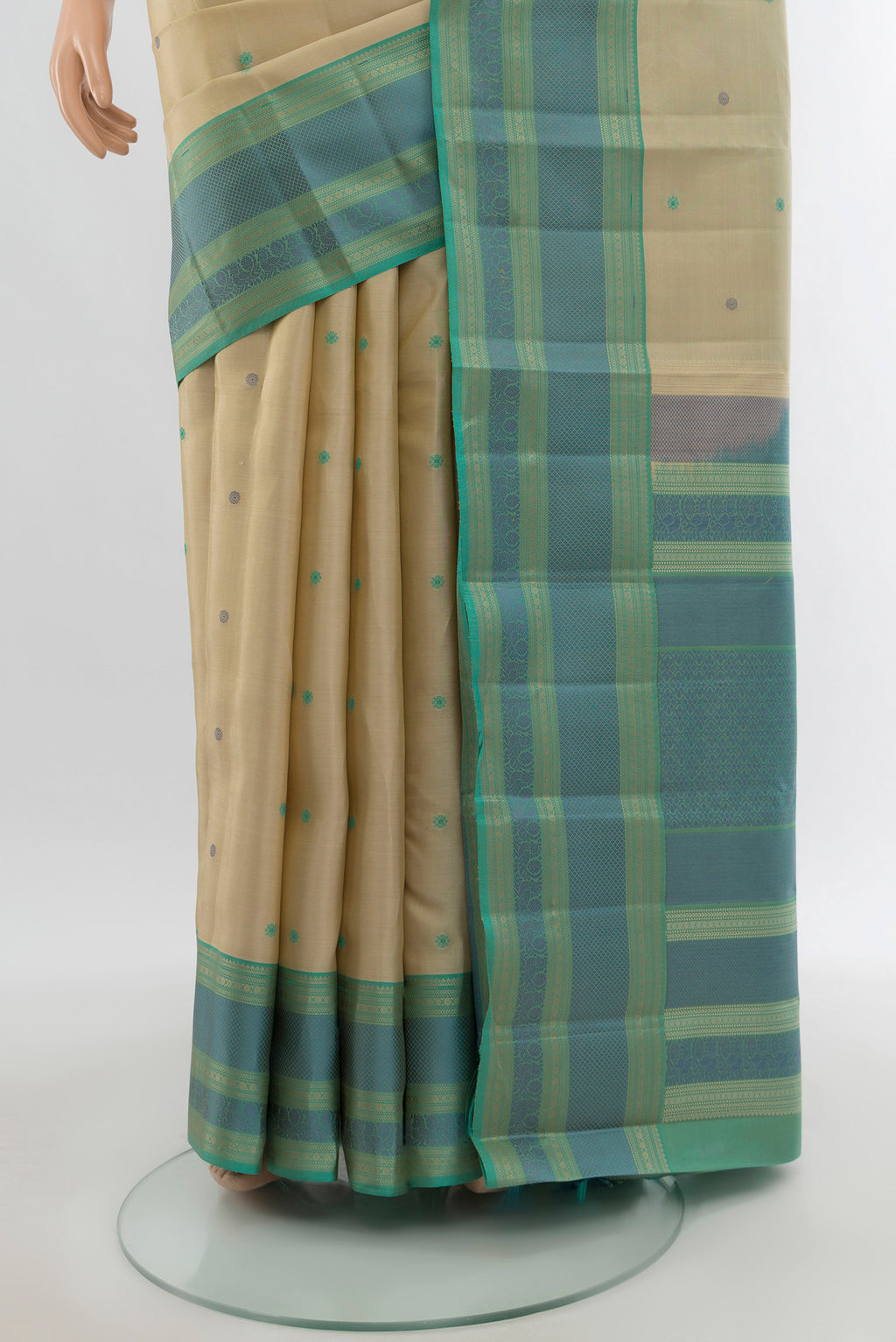 Pleats and pallu of Beige Kanchipuram Silk Saree with Thread Butta on the body and Thread Border. 