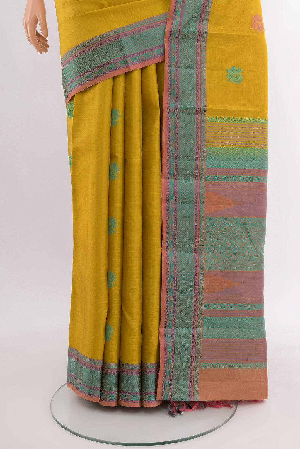 Pleats and pallu of Mustard Kanchipuram Silk Saree with Zari Butta on the body and Silk Border. 