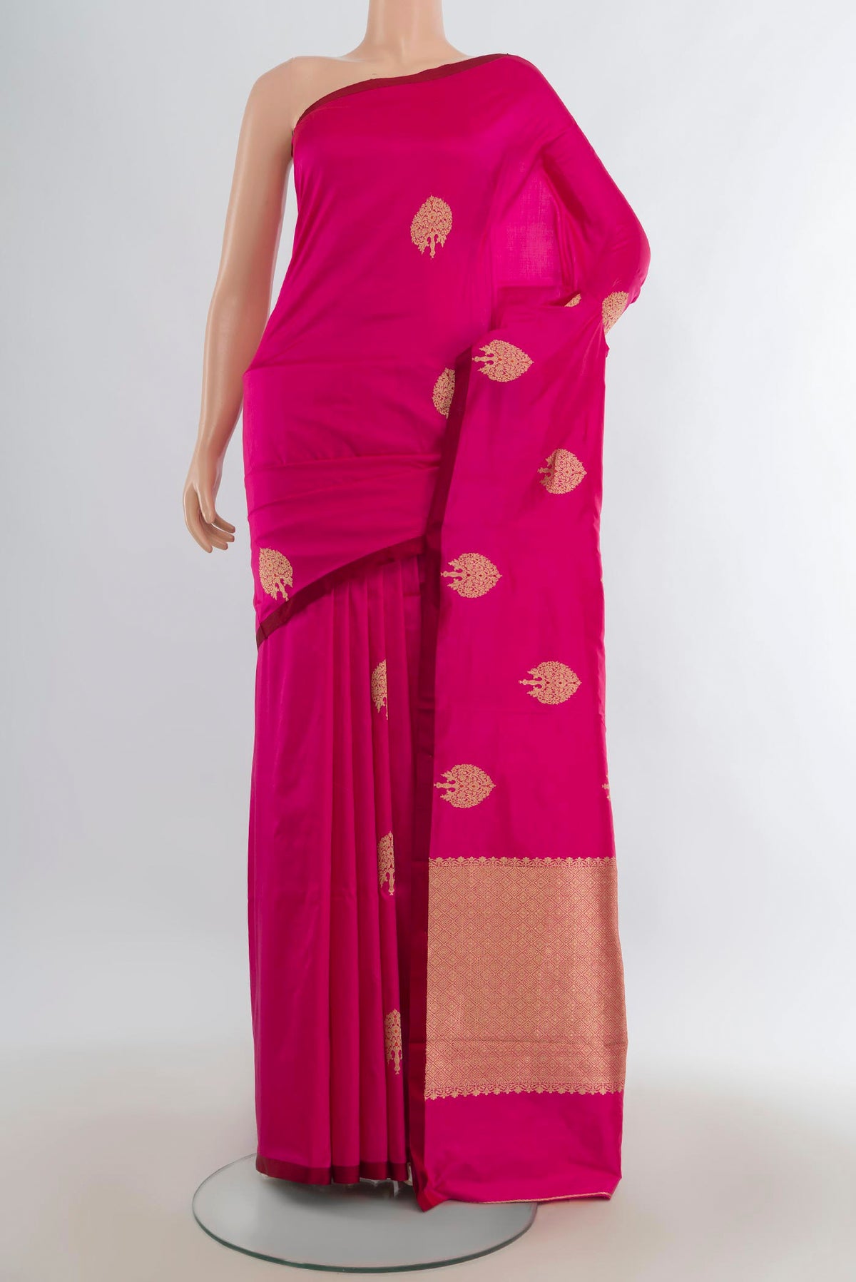 Pure Silk Rani Pink Banarasi Katan Saree with Zari Butta on the body and Without Border.  displayed on a mannequin