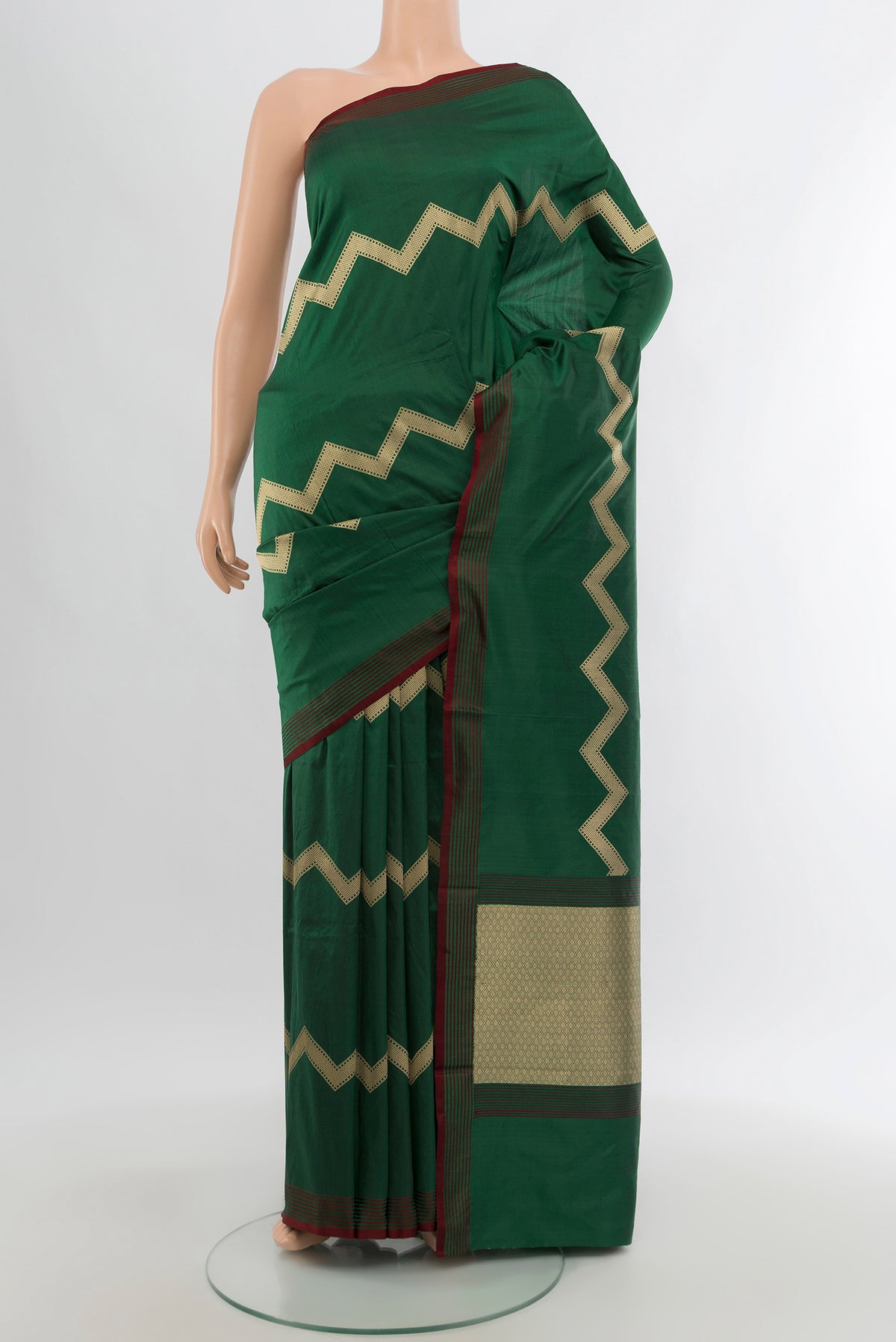 Bottle Green Banarasi Katan Silk Saree with Zig Zag design on the body and Plain Border.  displayed on a mannequin