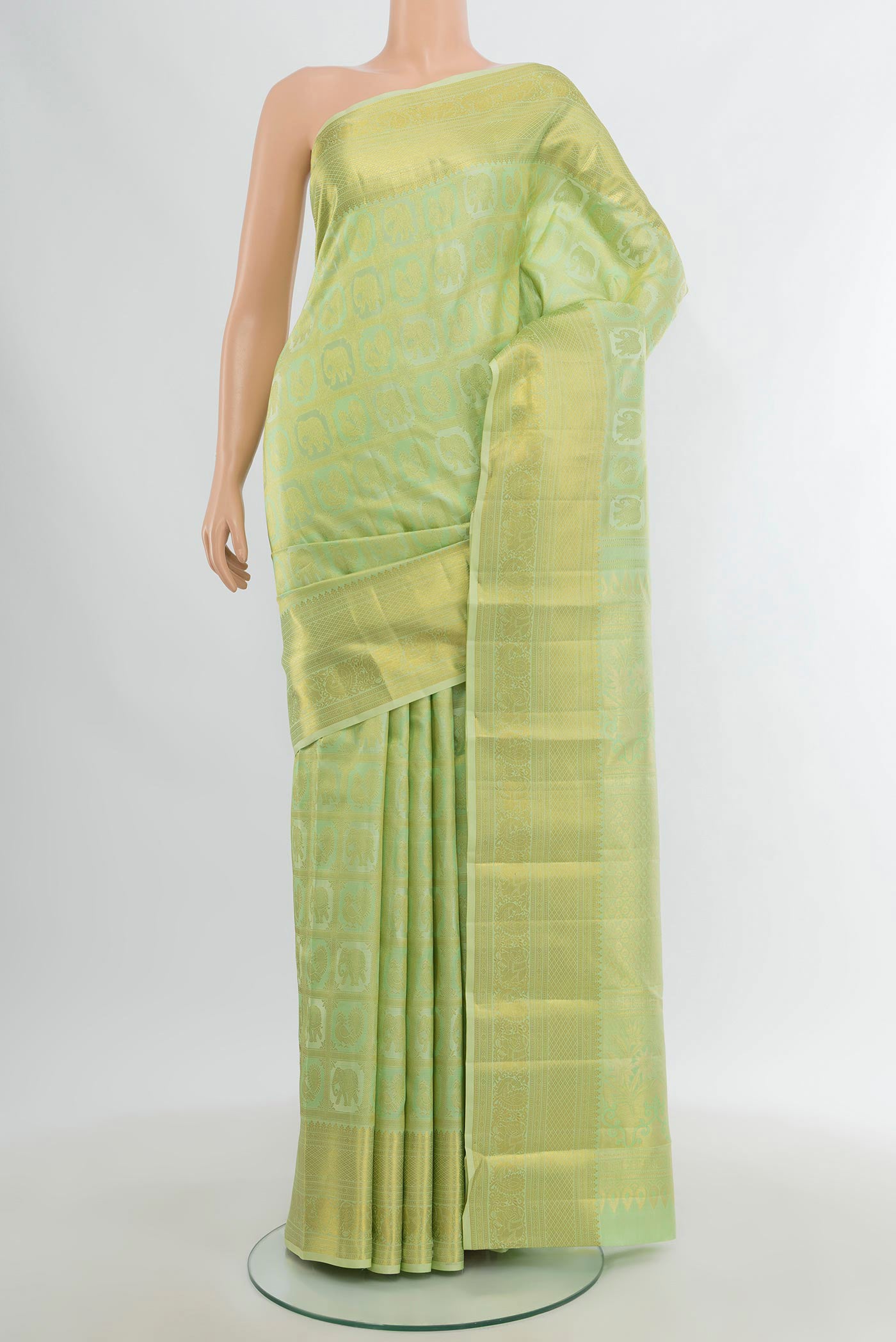 Pista Green Kanchipuram Silk Saree with Zari Butta on the body and Zari Border.  displayed on a mannequin