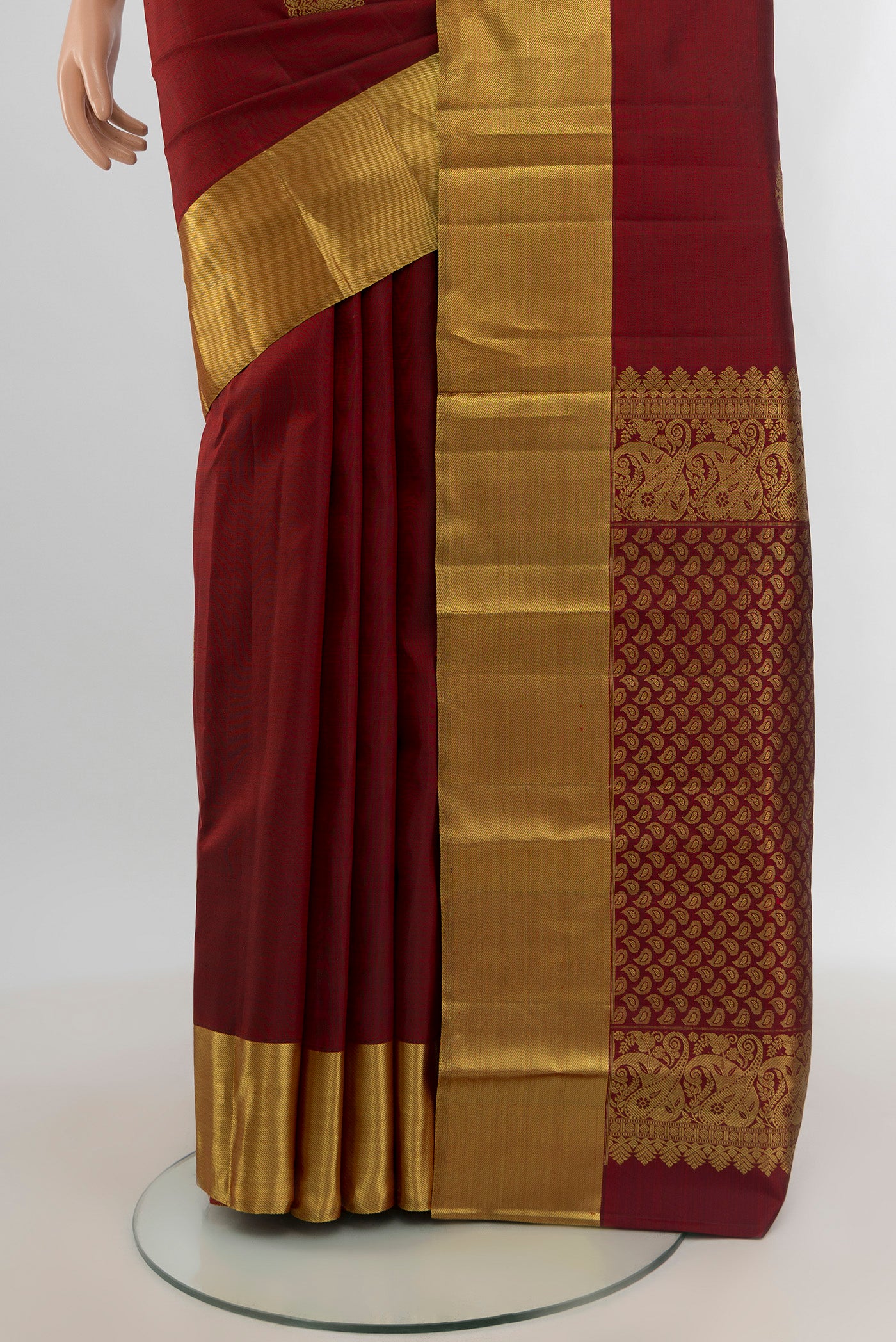 Pleats and pallu of Maroon Kanchipuram Silk Saree with Zari Butta on the body and Zari Border. 