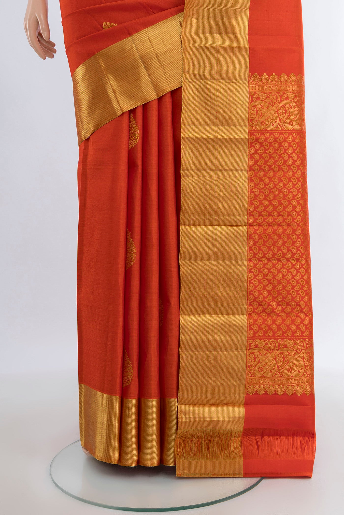 Pleats and pallu of Orange Kanchipuram Silk Saree with Zari Butta on the body and Zari Border. 