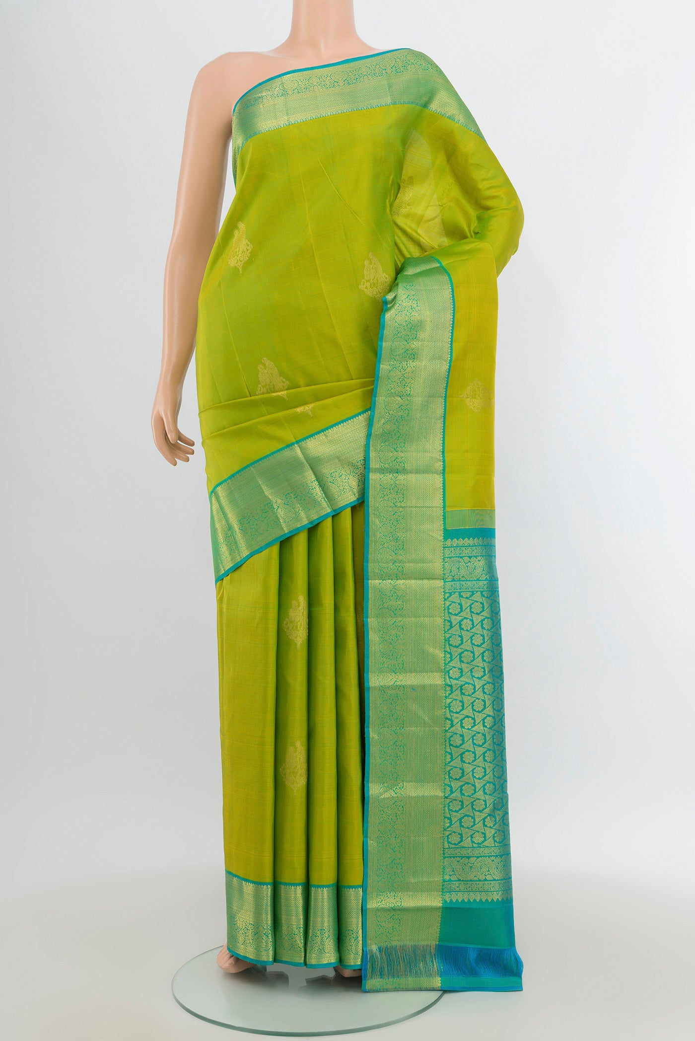 Parrot Green Kanchipuram Silk Saree with Zari Butta on the body and Silk Border.  displayed on a mannequin