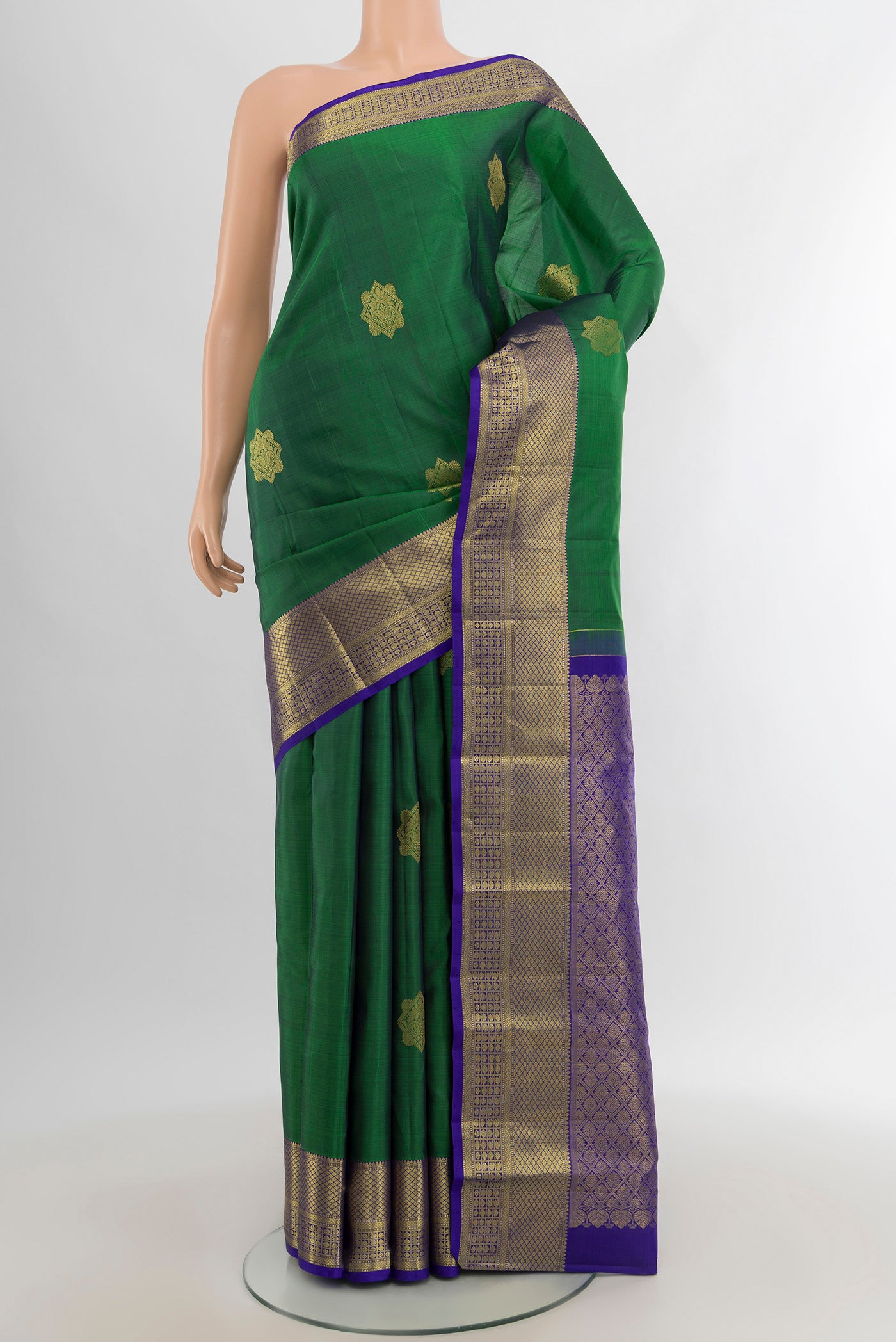 Green Kanchipuram Silk Saree with Zari Butta on the body and Zari Border.  displayed on a mannequin