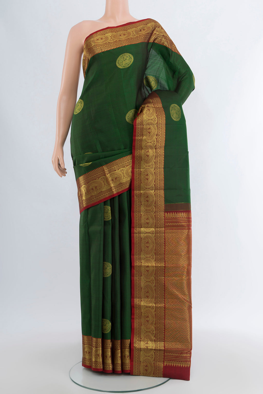 Bottle Green Kanchipuram Silk Saree with Zari Butta on the body and Zari Border.  displayed on a mannequin