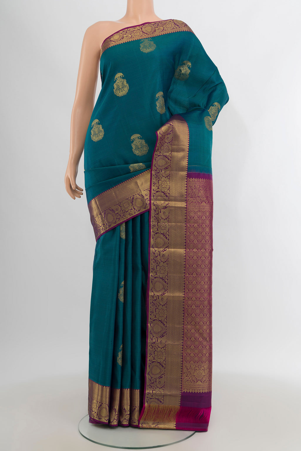 Peacock Blue Kanchipuram Silk Saree with Zari Butta on the body and Zari Border.  displayed on a mannequin