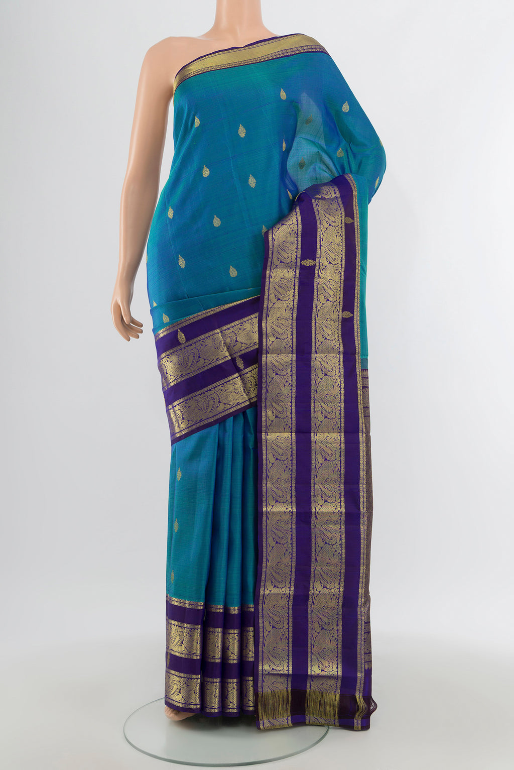 Peacock Blue Kanchipuram Silk Saree with Zari Butta on the body and Silk Border.  displayed on a mannequin