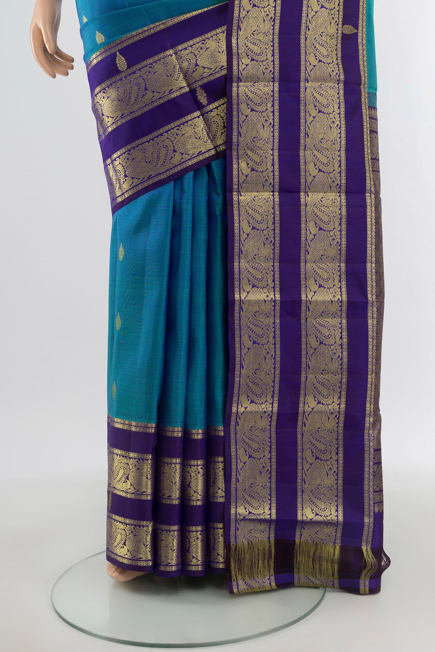 Pleats and pallu of Peacock Blue Kanchipuram Silk Saree with Zari Butta on the body and Silk Border. 