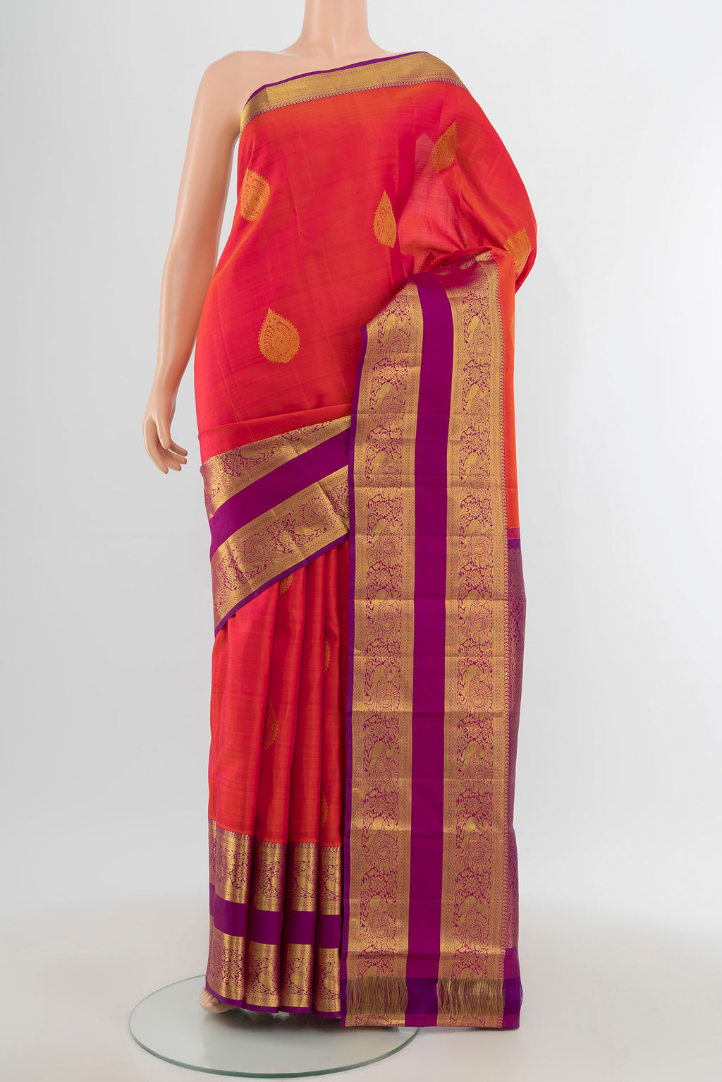 Brick Orange Kanchipuram Silk Saree with Zari Butta on the body and Zari Border.  displayed on a mannequin