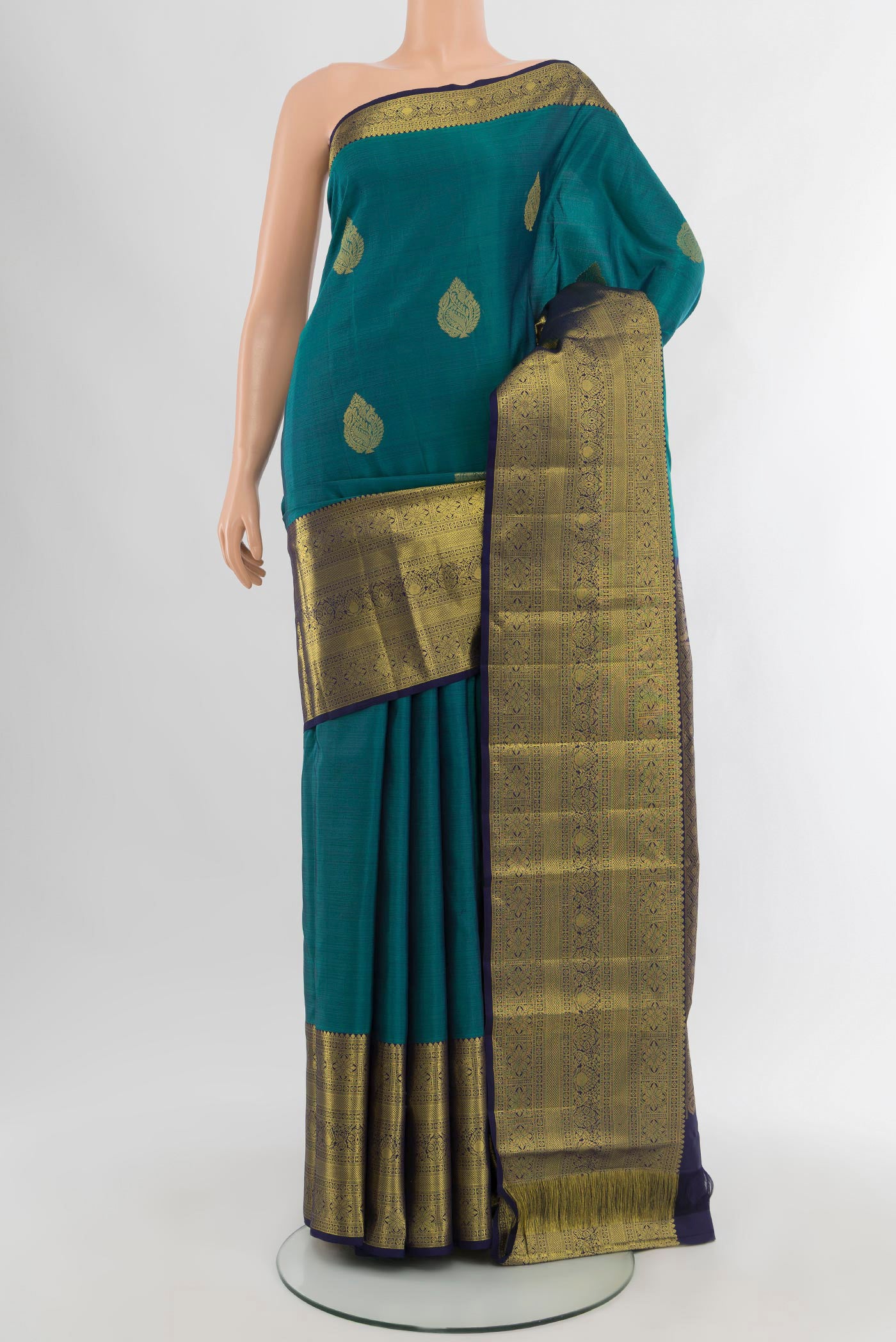 Peacock Blue Kanchipuram Silk Saree with Zari Butta on the body and Zari Border.  displayed on a mannequin