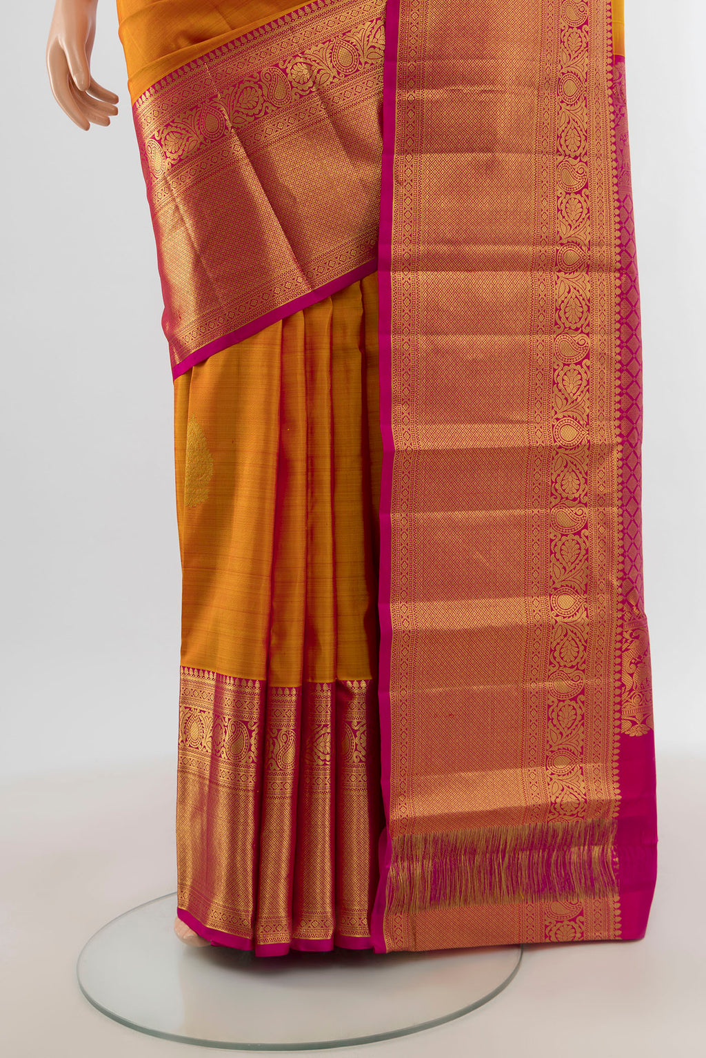 Pleats and pallu of Mustard Kanchipuram Silk Saree with Zari Butta on the body and Zari Border. 
