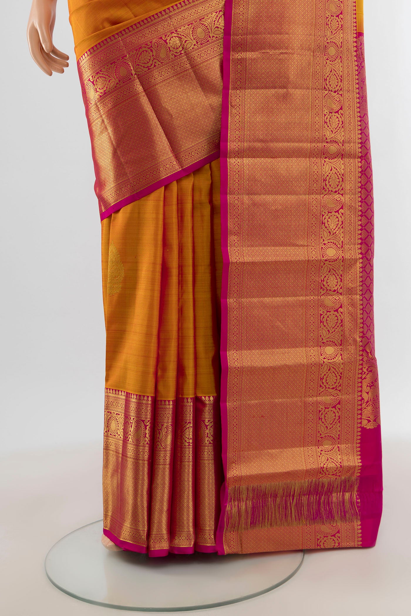 Pleats and pallu of Mustard Kanchipuram Silk Saree with Zari Butta on the body and Zari Border. 
