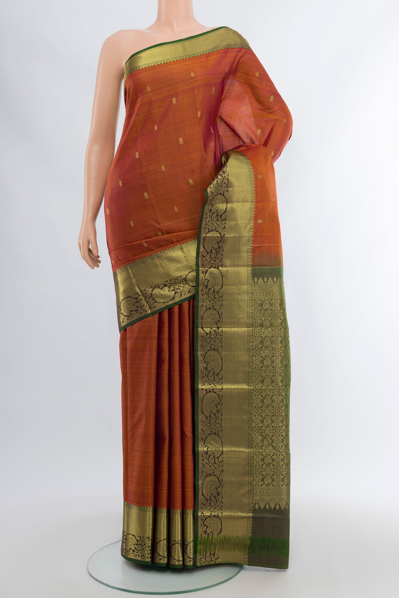 Pure Silk Pure Zari Rust Kanchipuram Saree with Zari Butta on the body and Silk Border.  displayed on a mannequin
