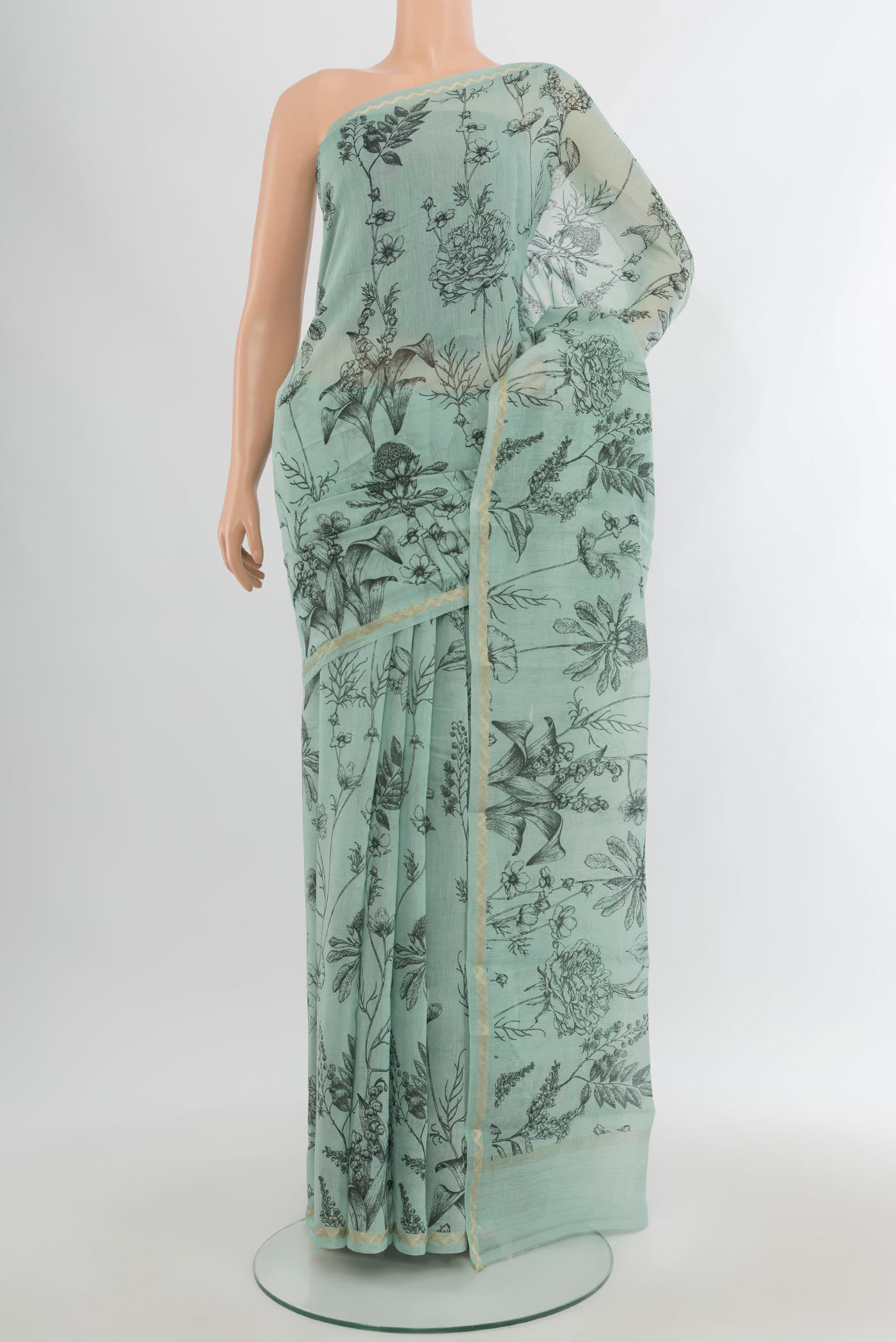 Light Blue Maheshwari Silk Cotton Saree with Floral Print on the body and Zari Border.  displayed on a mannequin