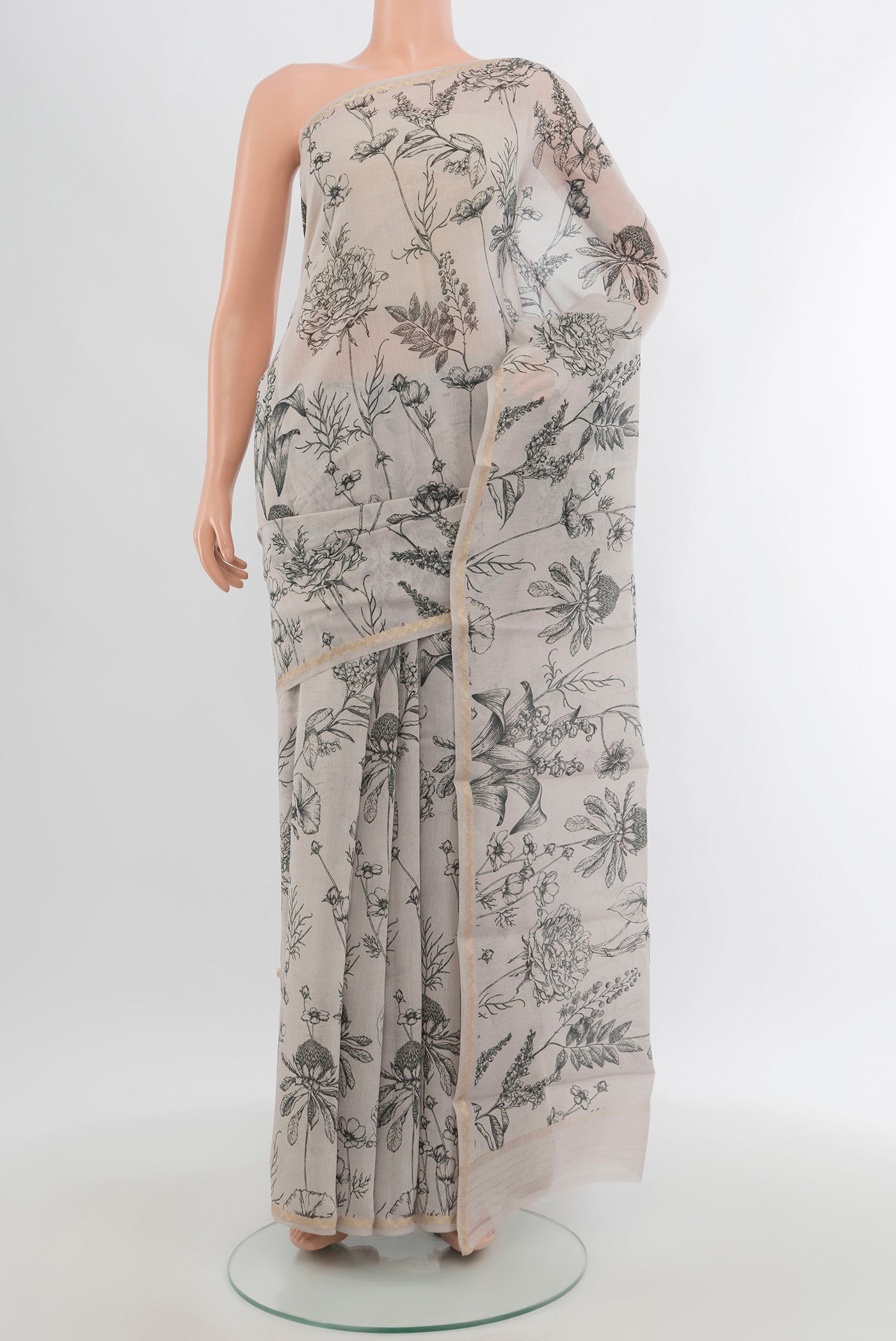 Grey Maheshwari Silk Cotton Saree with Floral Print on the body and Thin Zari Line.  displayed on a mannequin