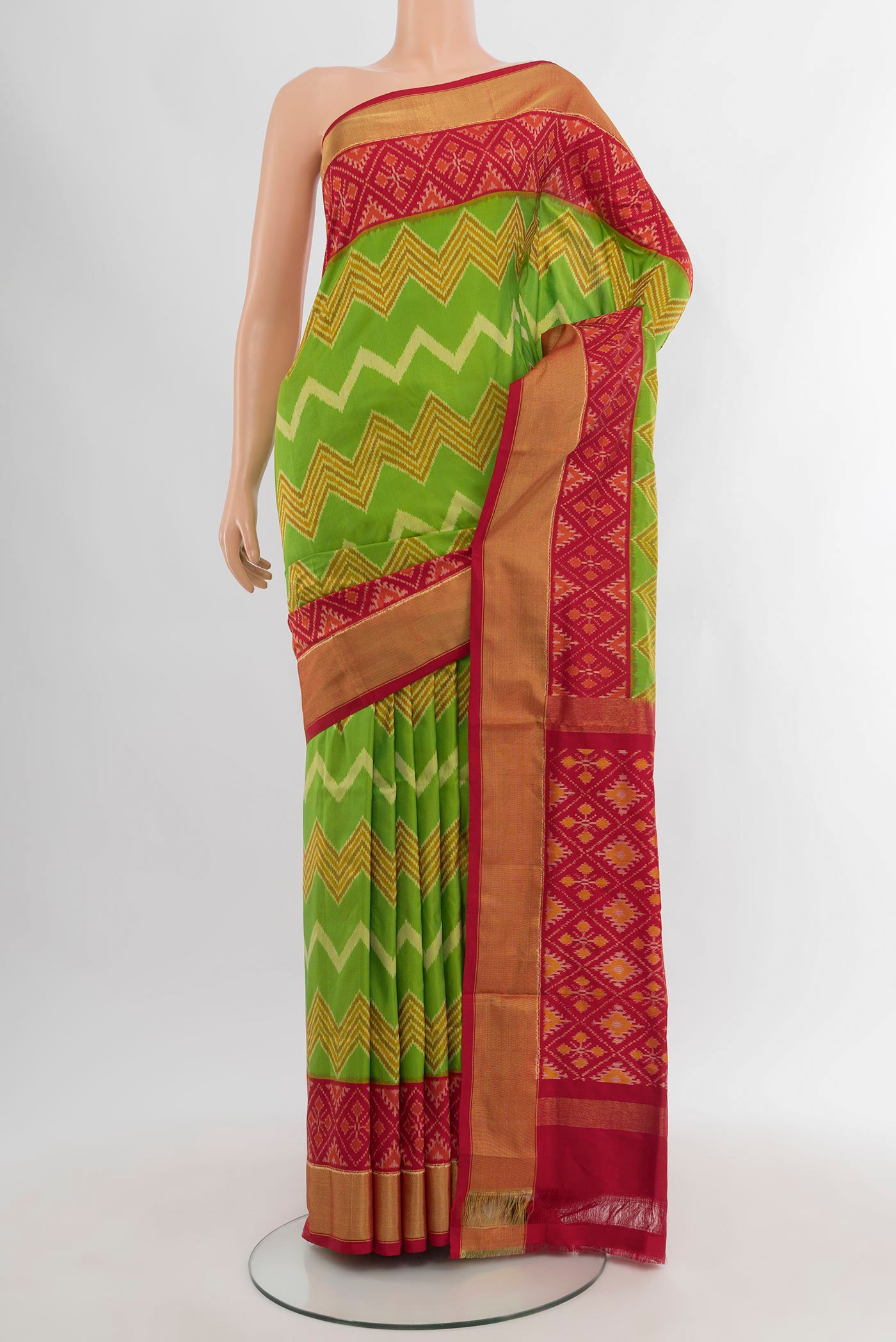Parrot Green Pochampally Silk Saree with Ikat design on the body and Ikat Border.  displayed on a mannequin