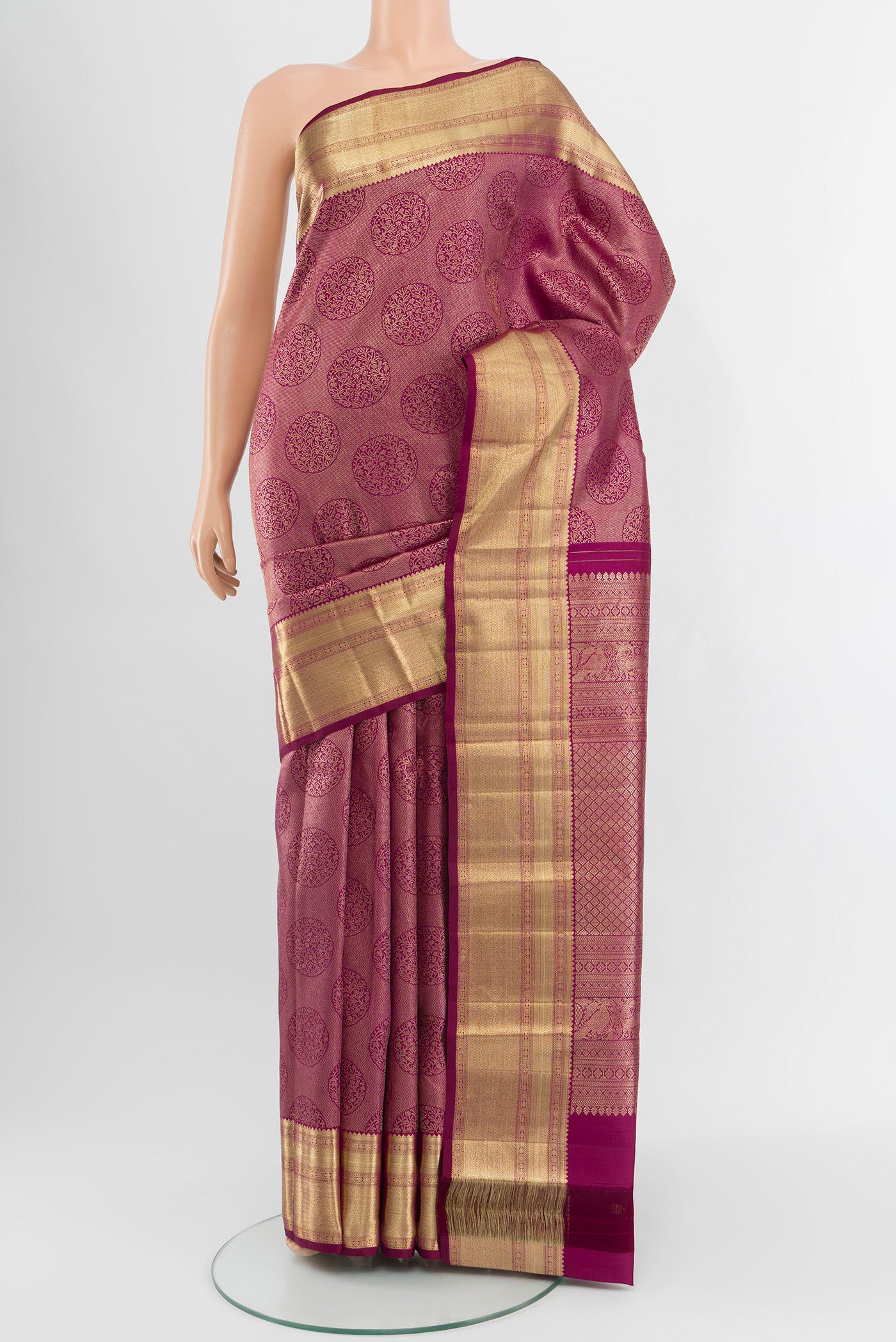 Magenta Kanchipuram Silk Saree with Zari Brocade on the body and Zari Border.  displayed on a mannequin